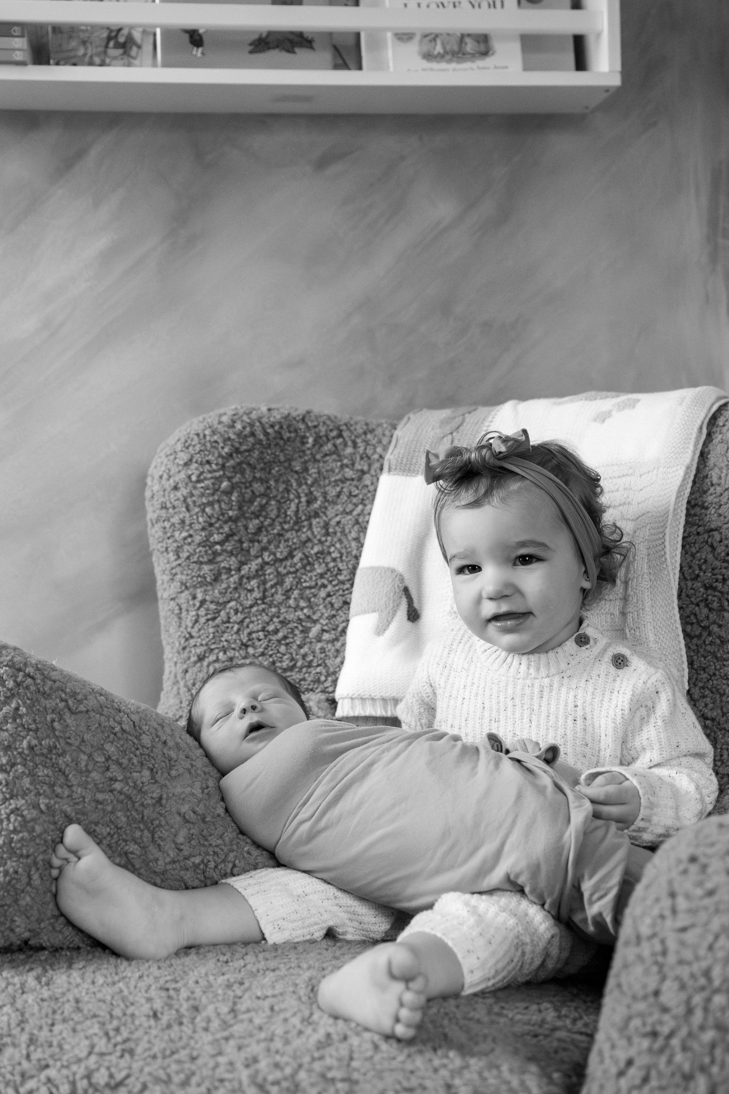 Black and white photos capturing a baby resting on a textured couch cushion.