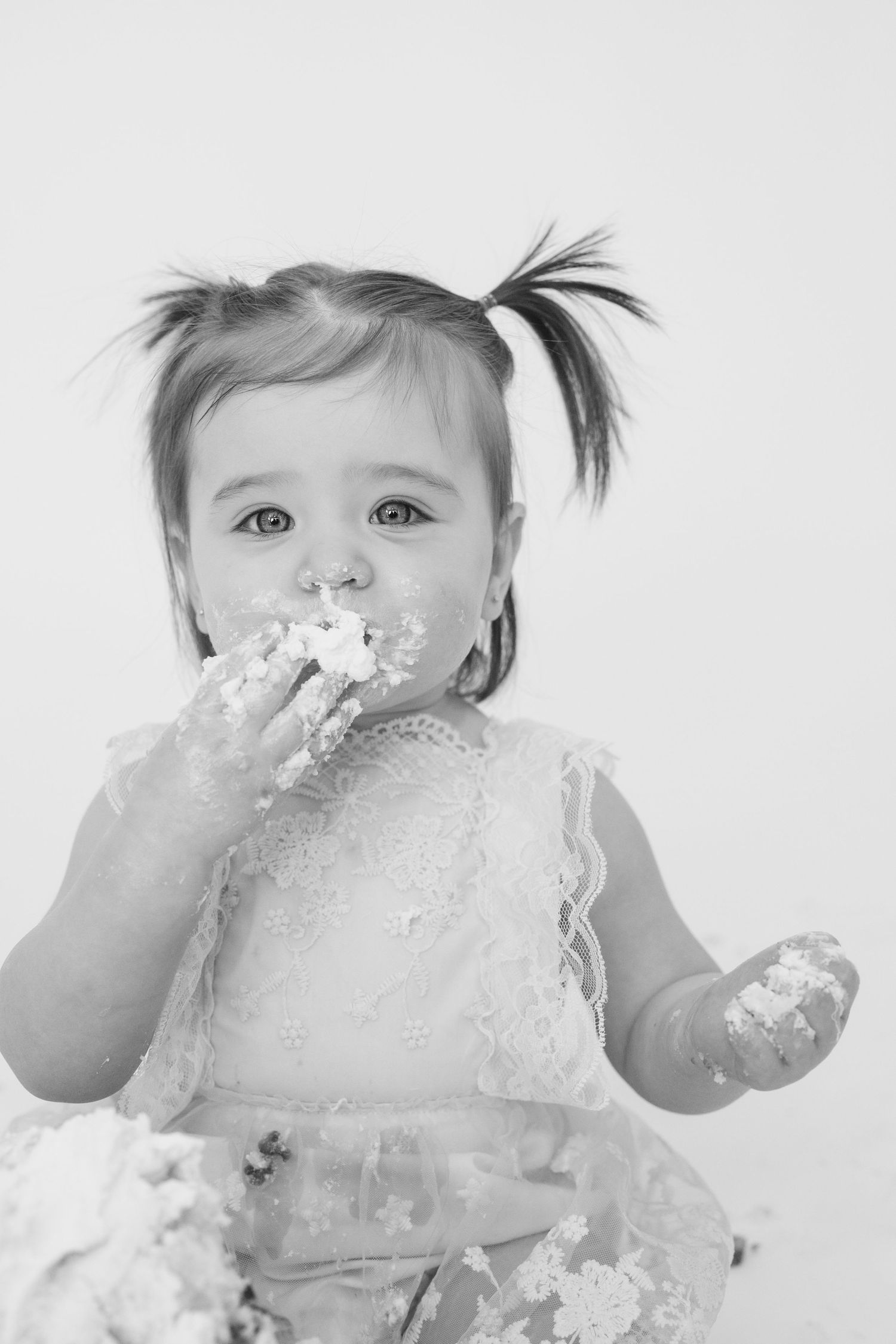 Black and white images of baby enjoying messy cake smash session.