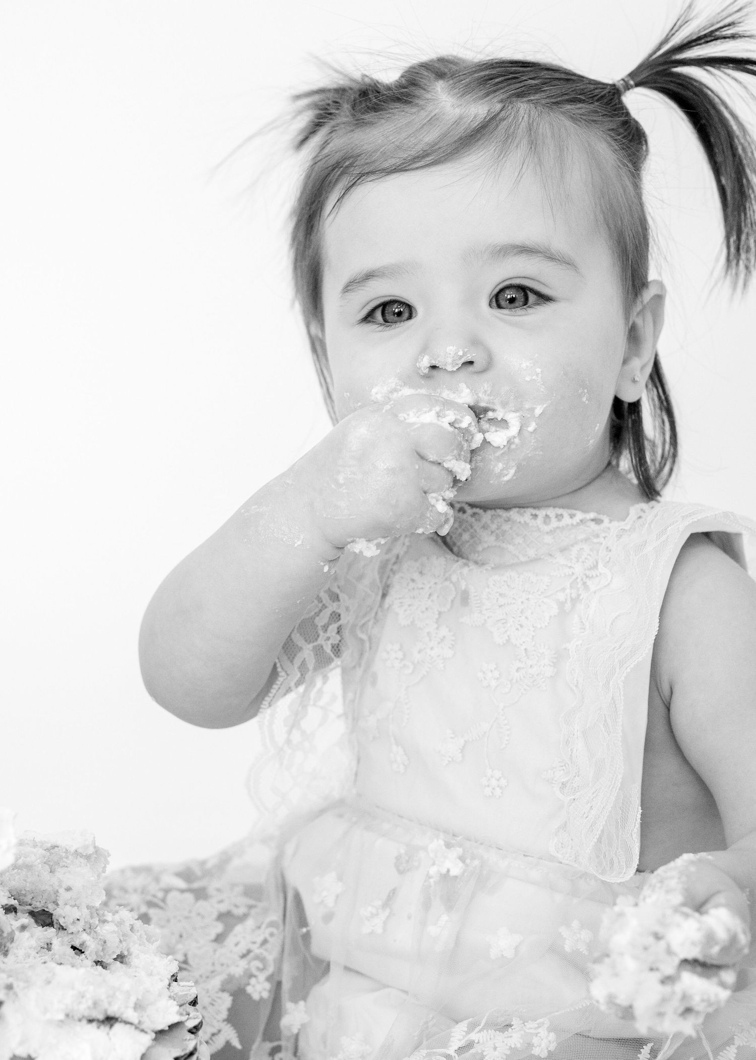 Black and white portrait series of baby getting messy with birthday cake.