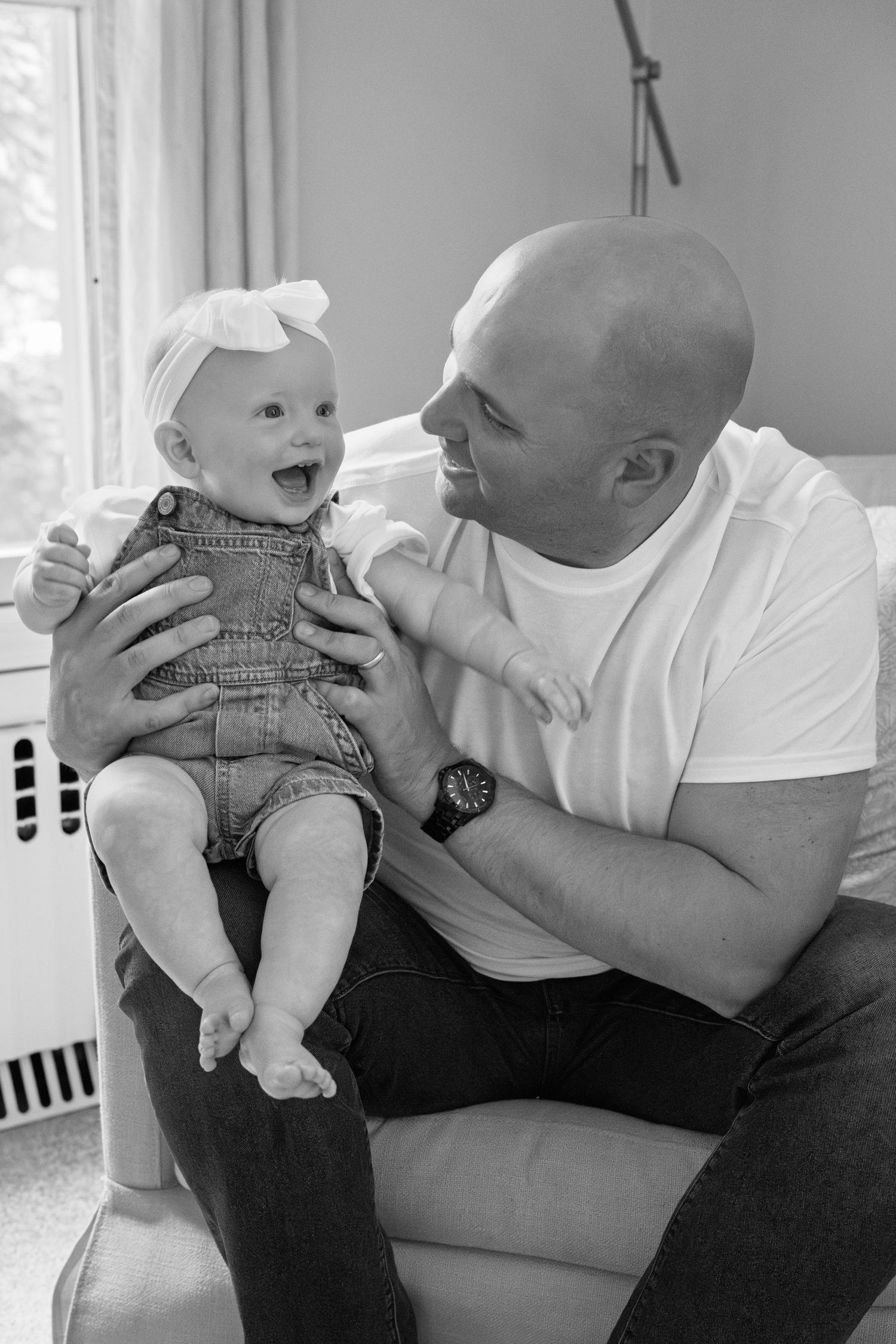 A tender moment between parent and baby captured in black and white as they play together.