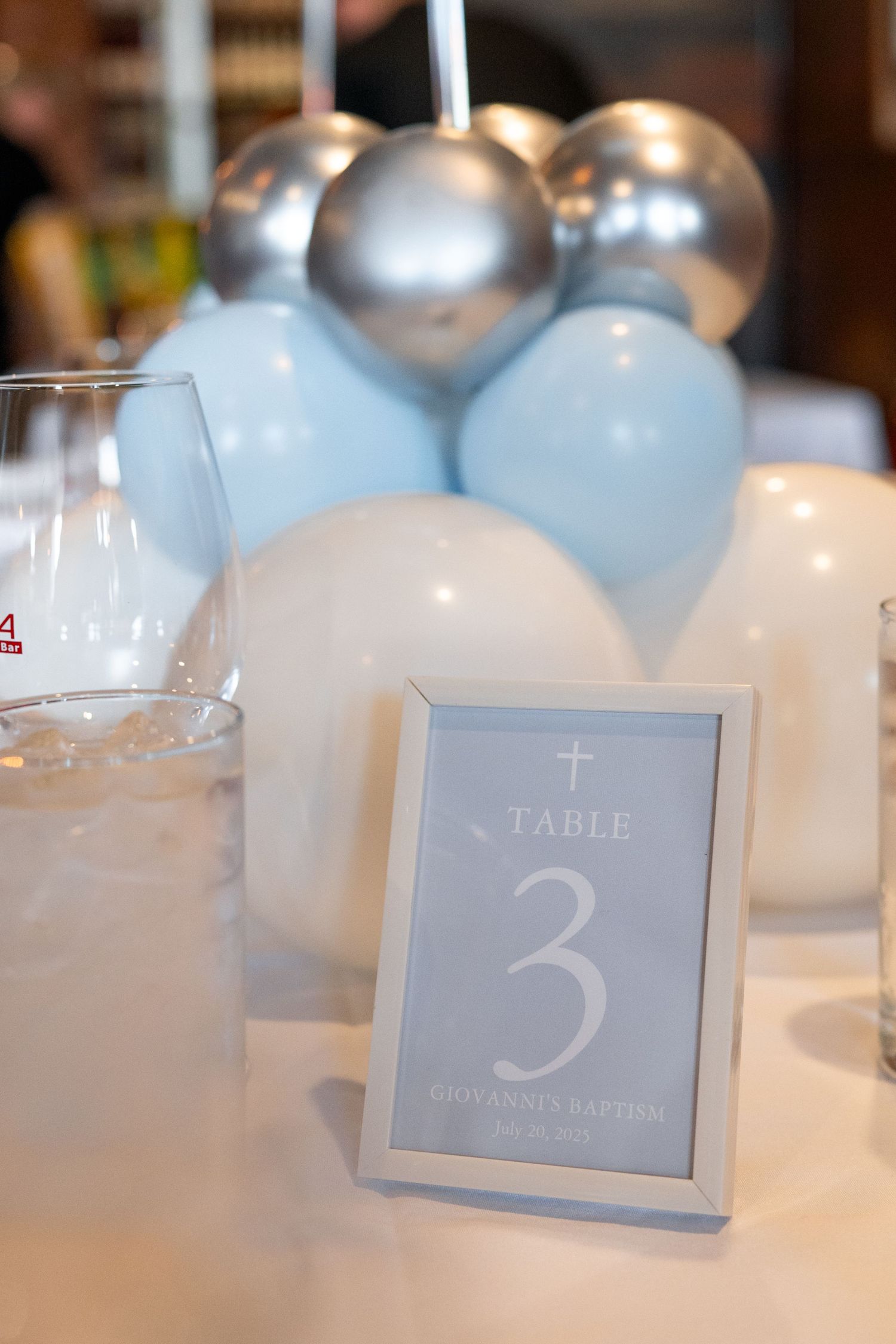 Table number cards in soft blue and white tones arranged at a formal event setting.