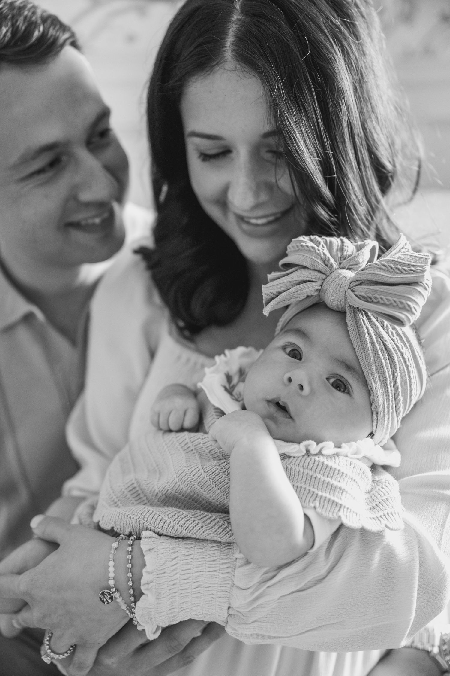 Black and white series showing tender family moments with a baby.