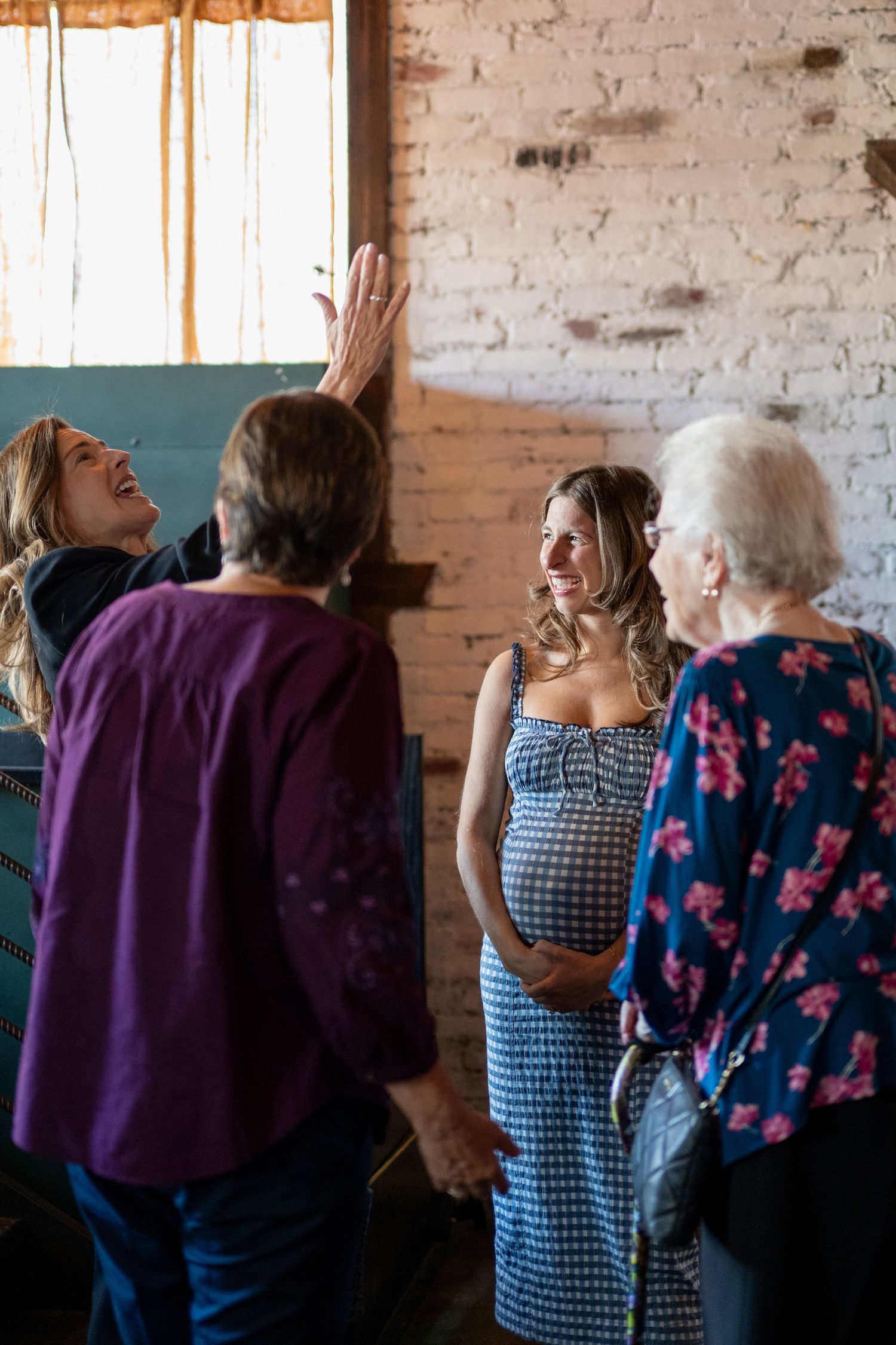 Guests mingling in a rustic venue with exposed brick walls and casual decor.