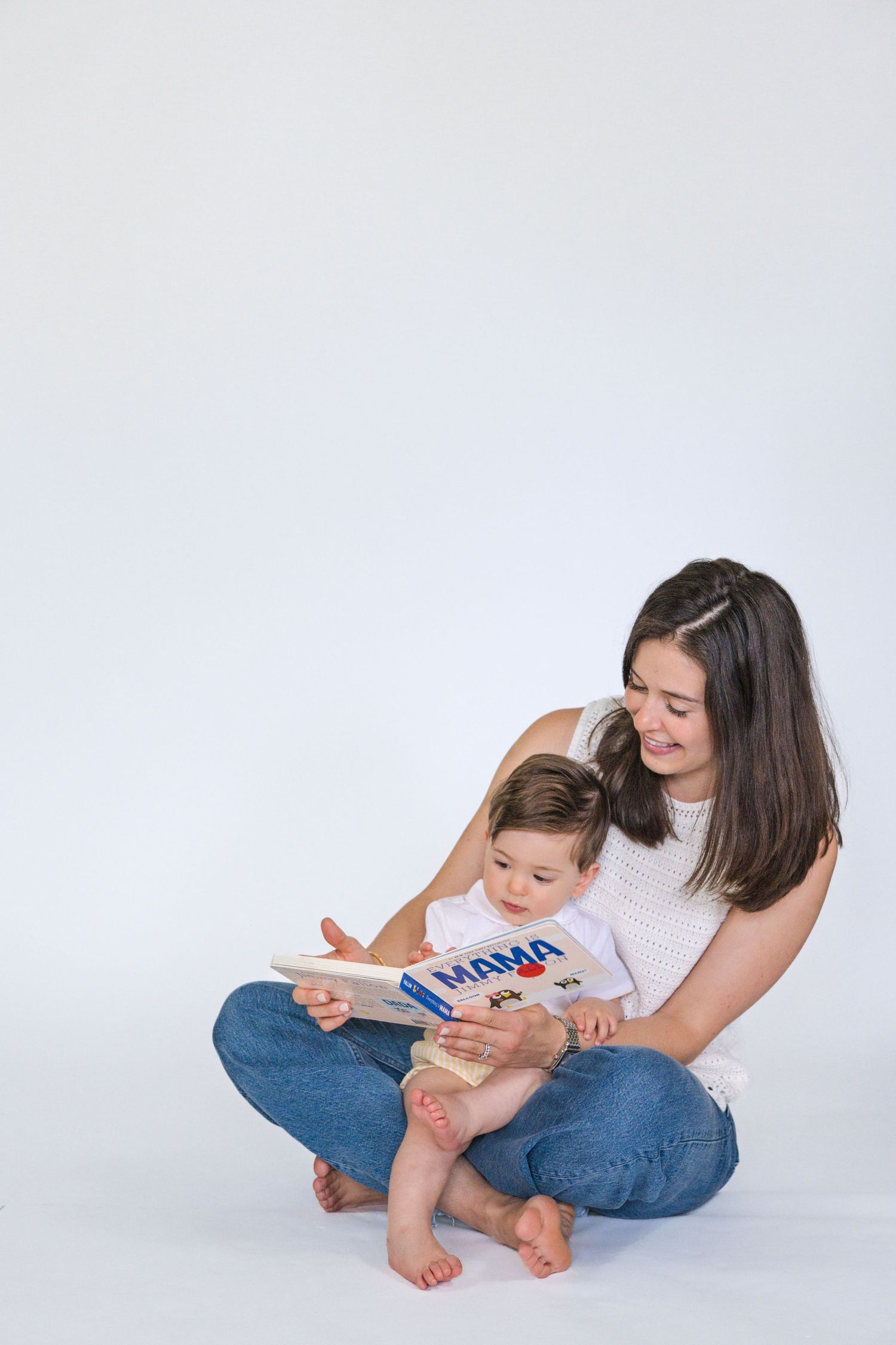 Intimate reading session captured in white studio setting showing connection and learning.