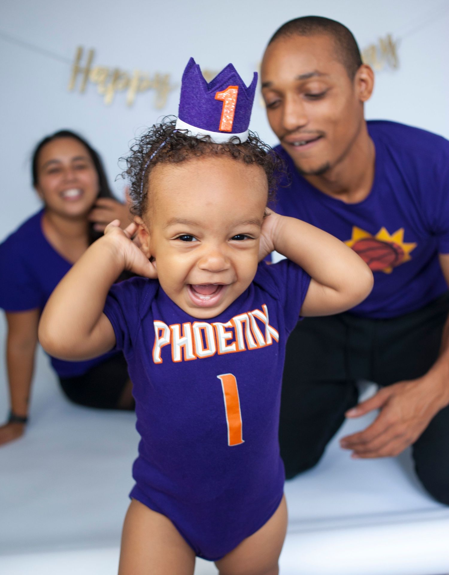 Baby wearing purple Phoenix sports onesie and crown celebrating first birthday.
