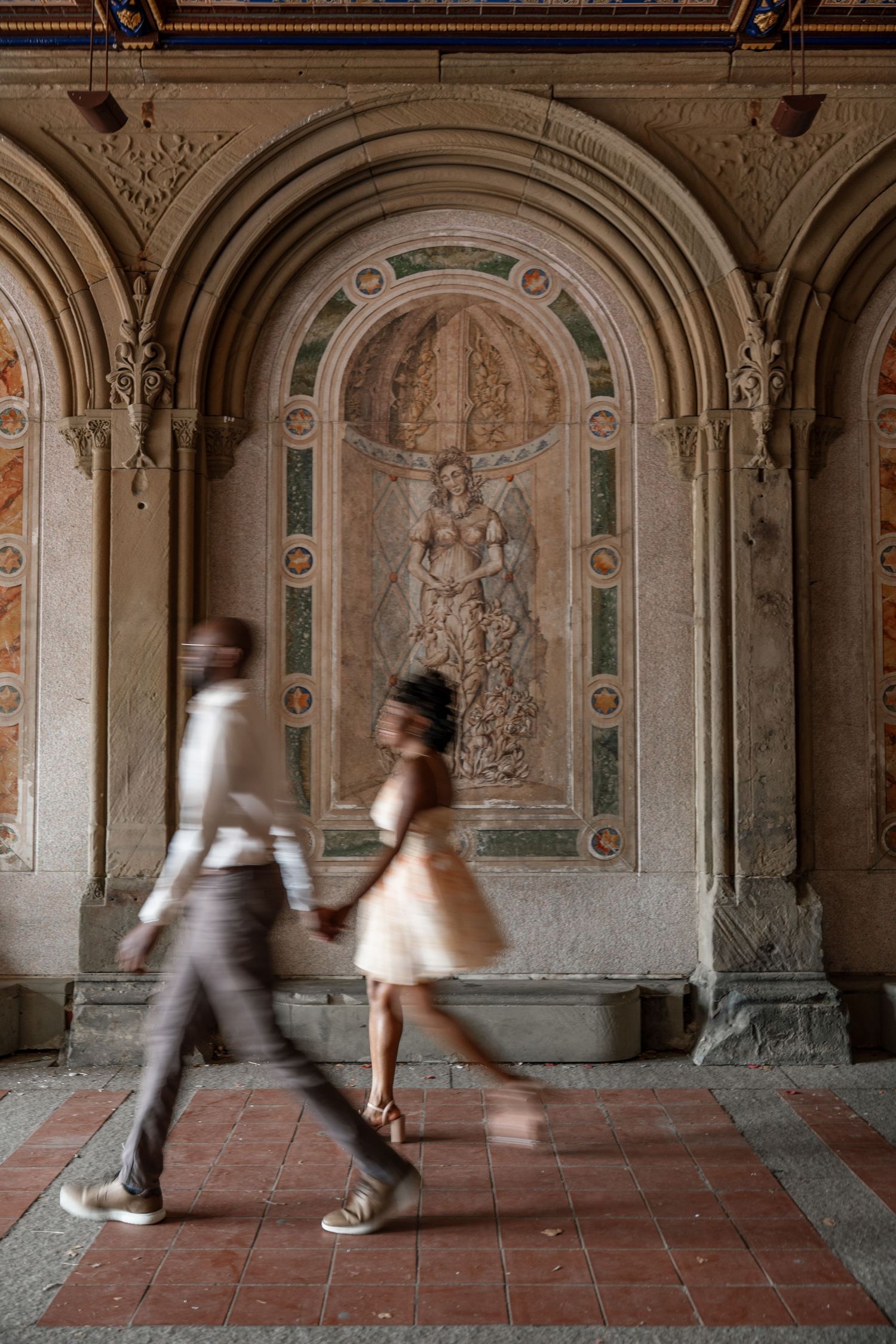 Motion-blurred figures dance through an elegant corridor with classical architectural details.