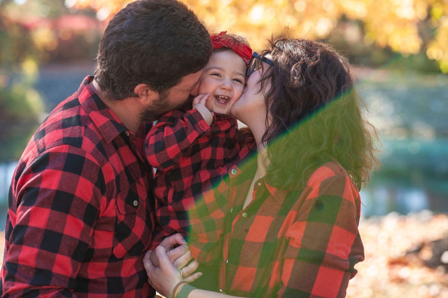 Romantic couple in buffalo plaid embracing outdoors during golden hour sunset in autumn.
