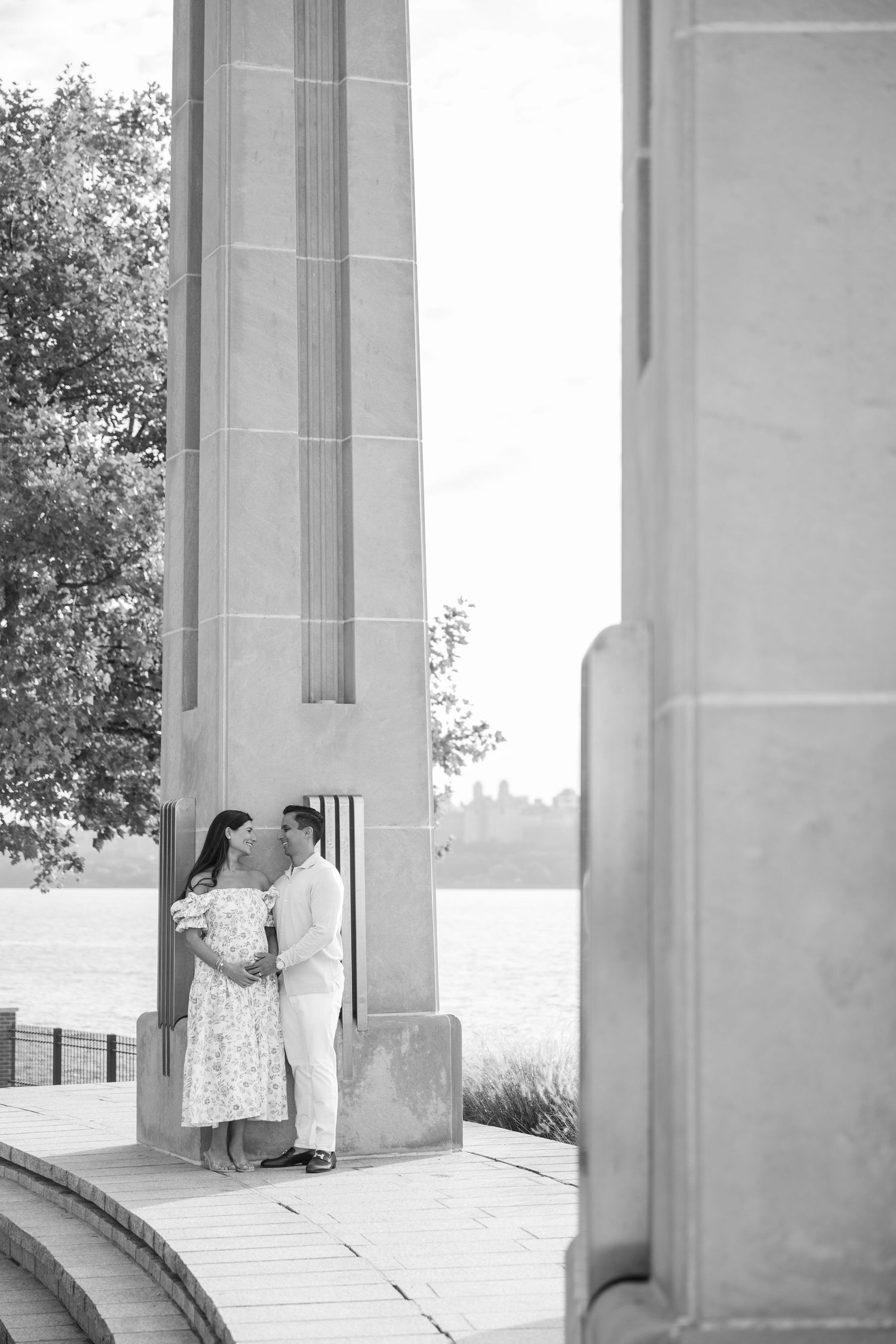 A romantic couple embraces near architectural columns in a series of black and white photos.
