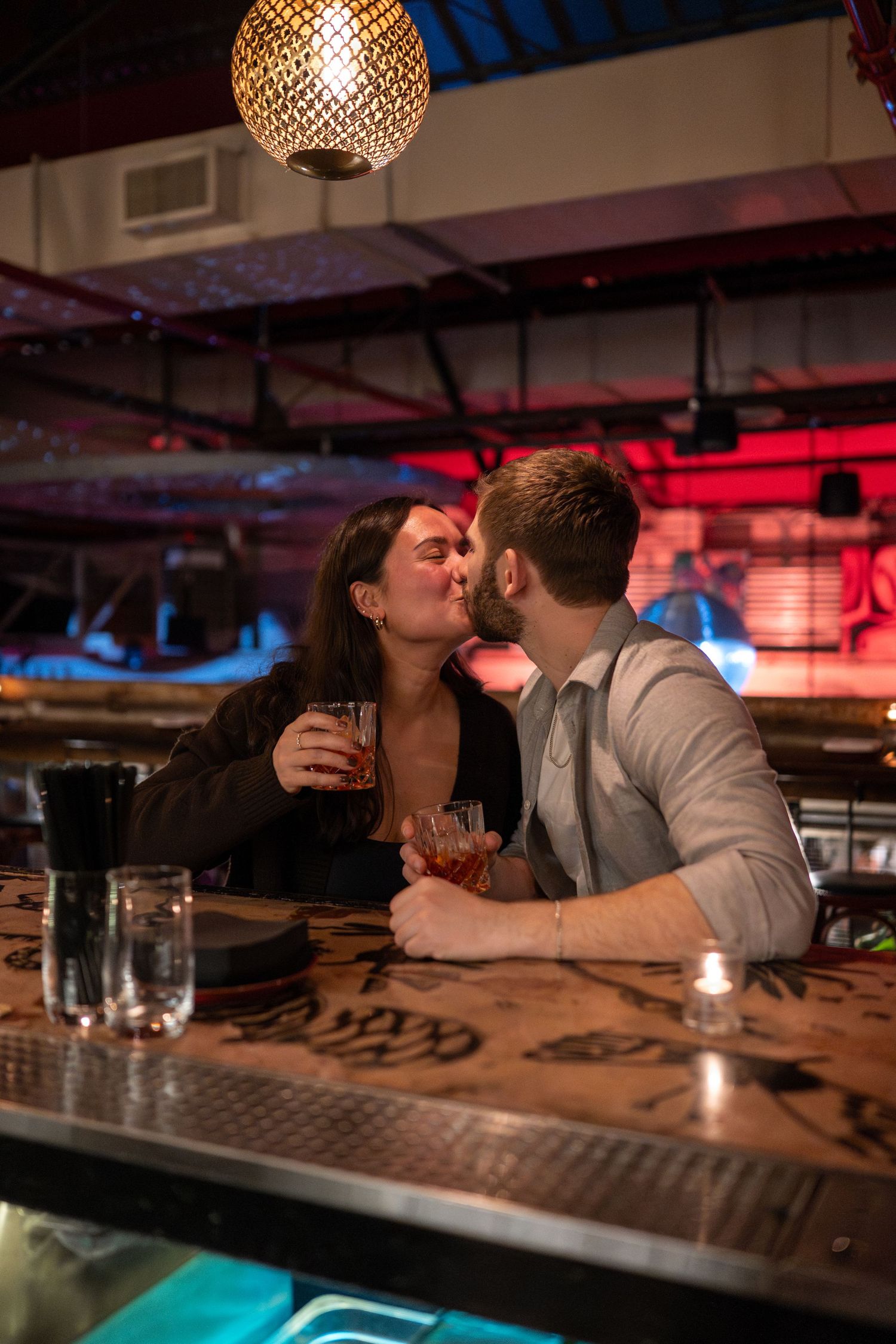 A romantic evening at a dimly lit bar with decorative lighting and colorful ambient mood lighting.