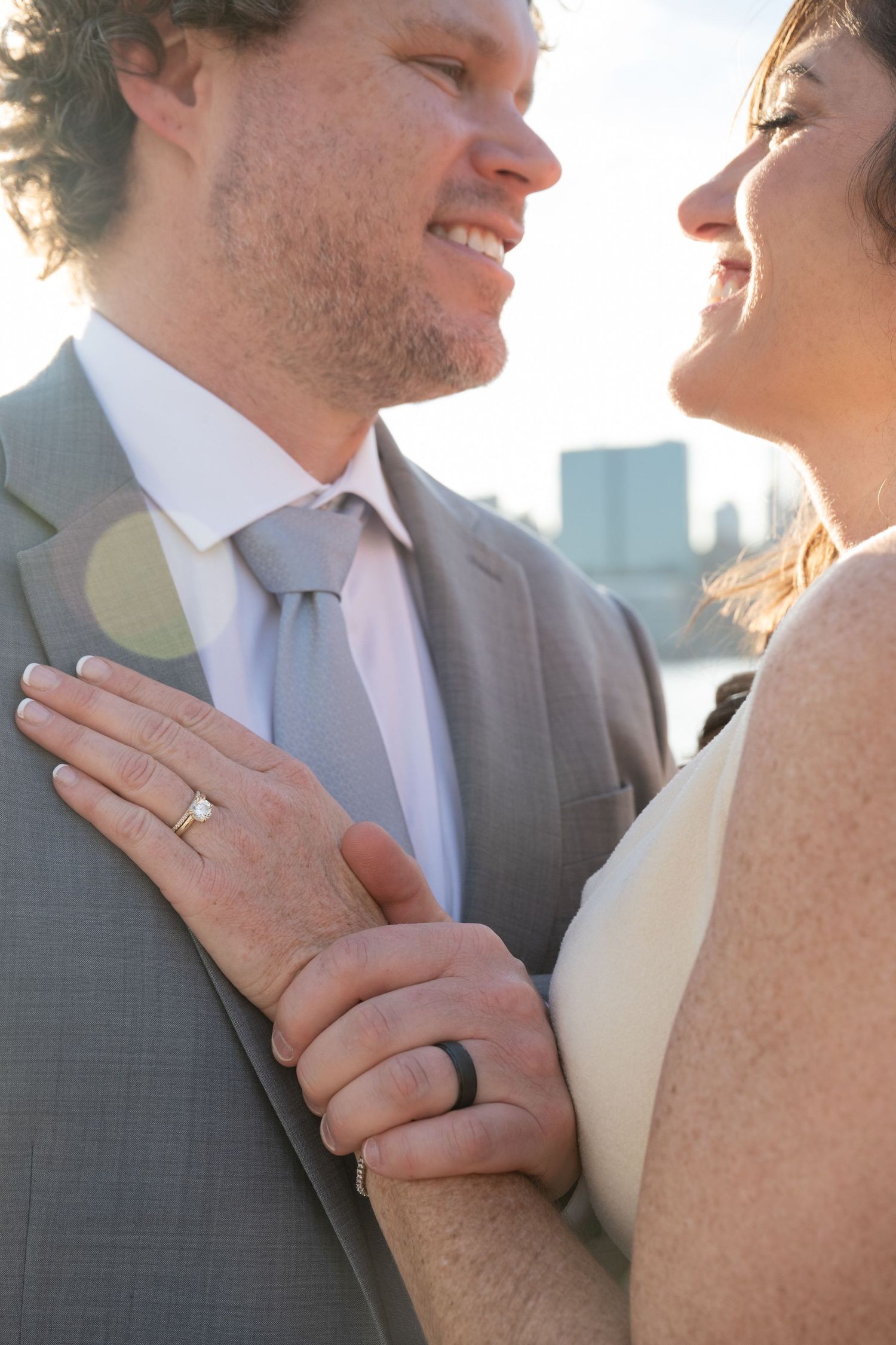 Close-up romantic wedding portraits showing tender moments between newlyweds against a soft background.