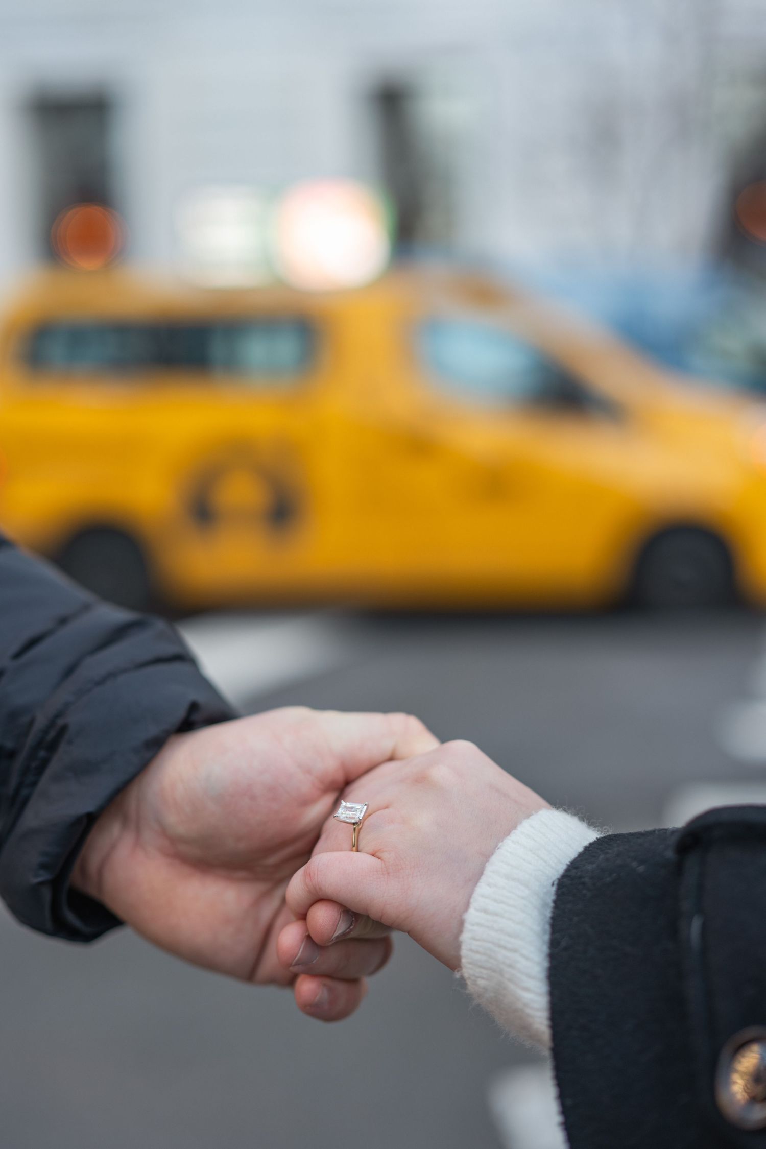 Close up sequence of hands with an engagement ring against a backdrop of yellow taxis in New York City.