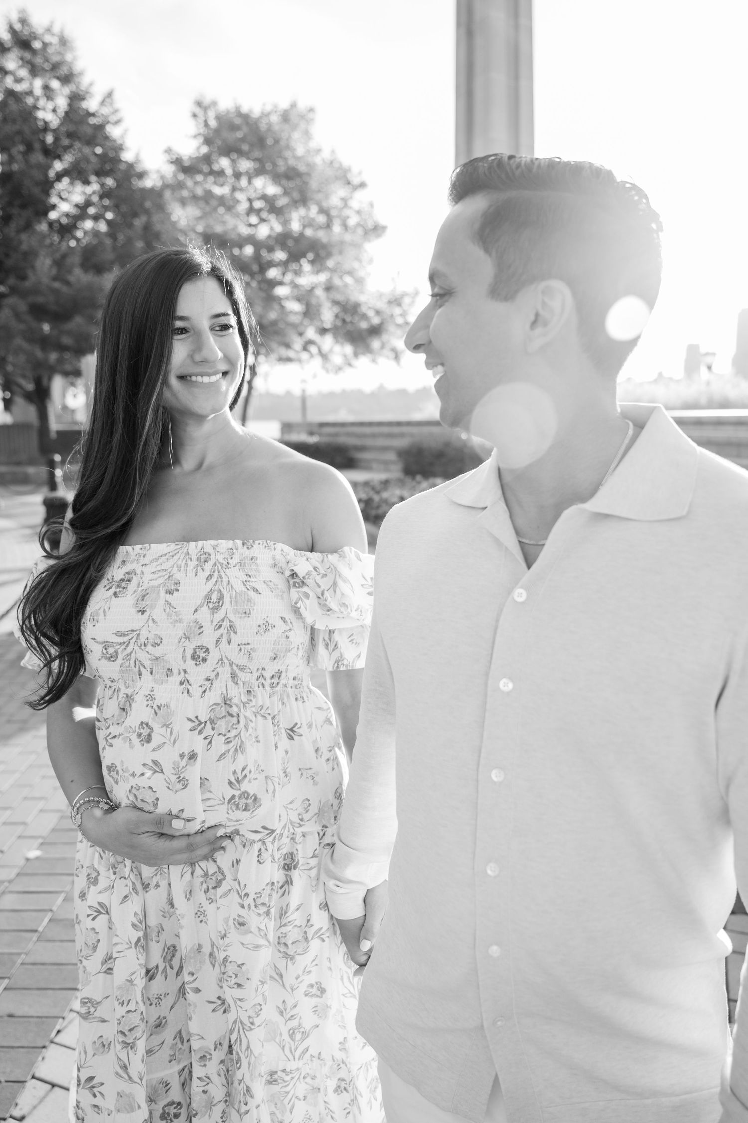 Romantic outdoor photoshoot showing couple in white and floral outfits.