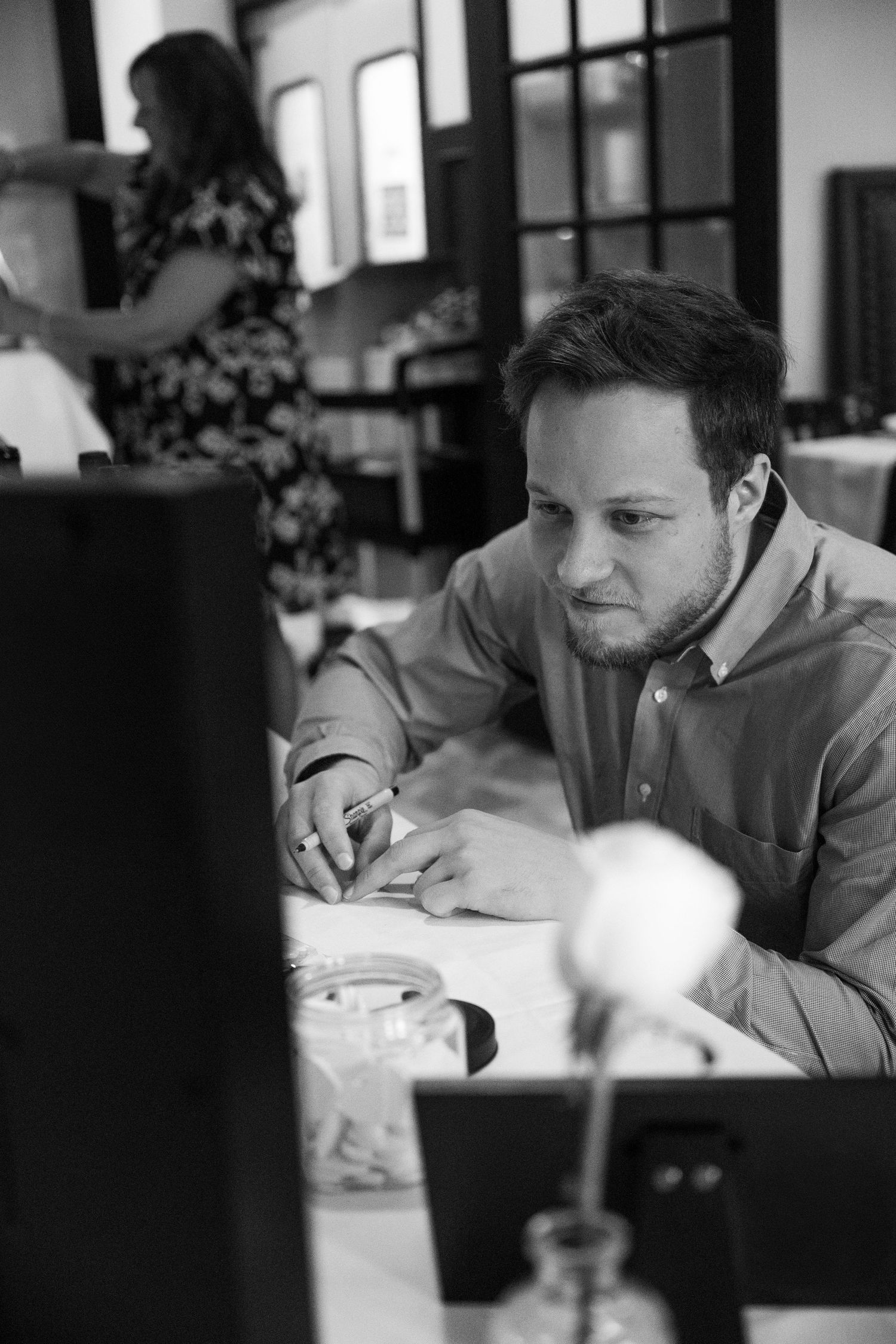Black and white photo sequence shows someone writing or studying at a table in what appears to be a cafe setting.