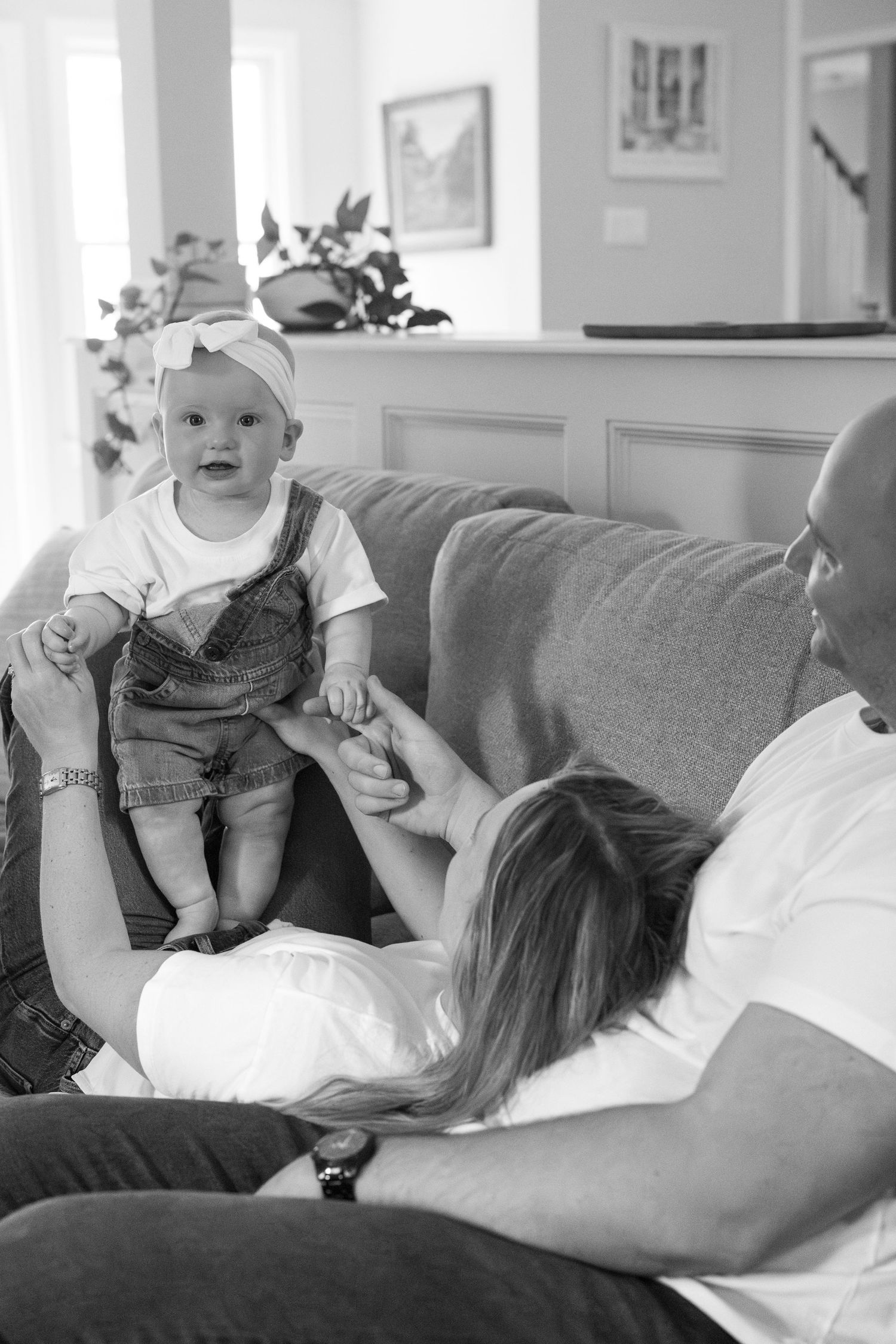 A sequence of candid moments showing playtime on a grey couch indoors.