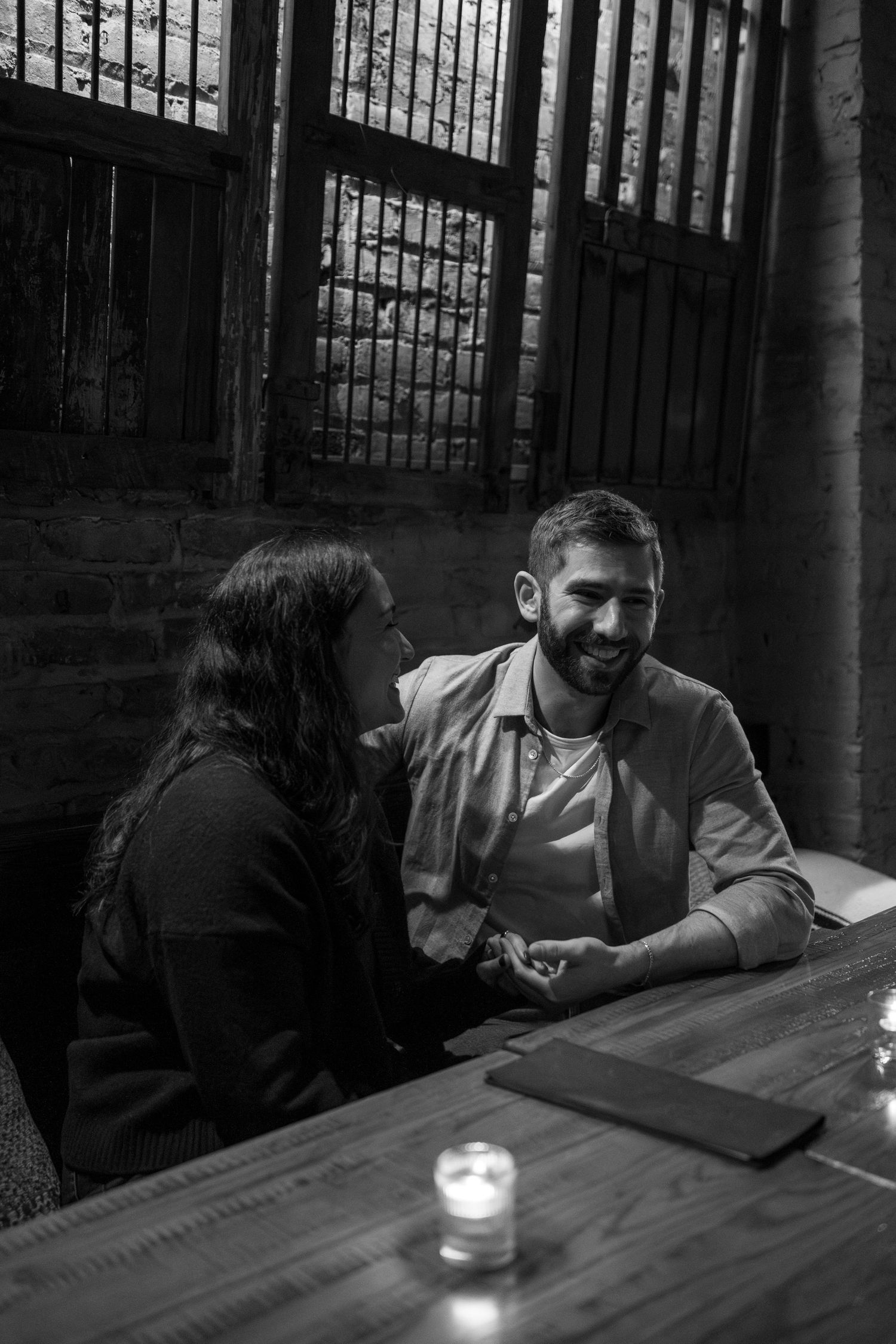 A romantic evening scene at a dimly lit table with a glowing candle creating intimate ambiance.
