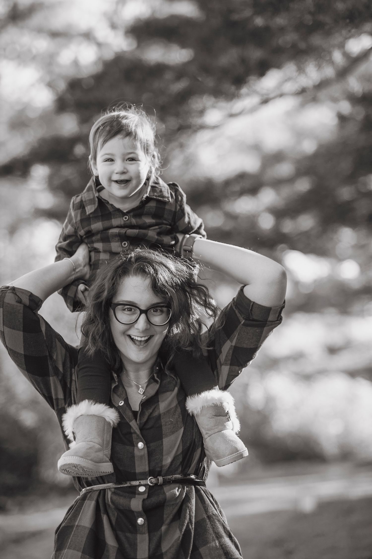 Candid black and white portrait sequence showing joyful expressions and plaid shirt against a blurred nature backdrop.