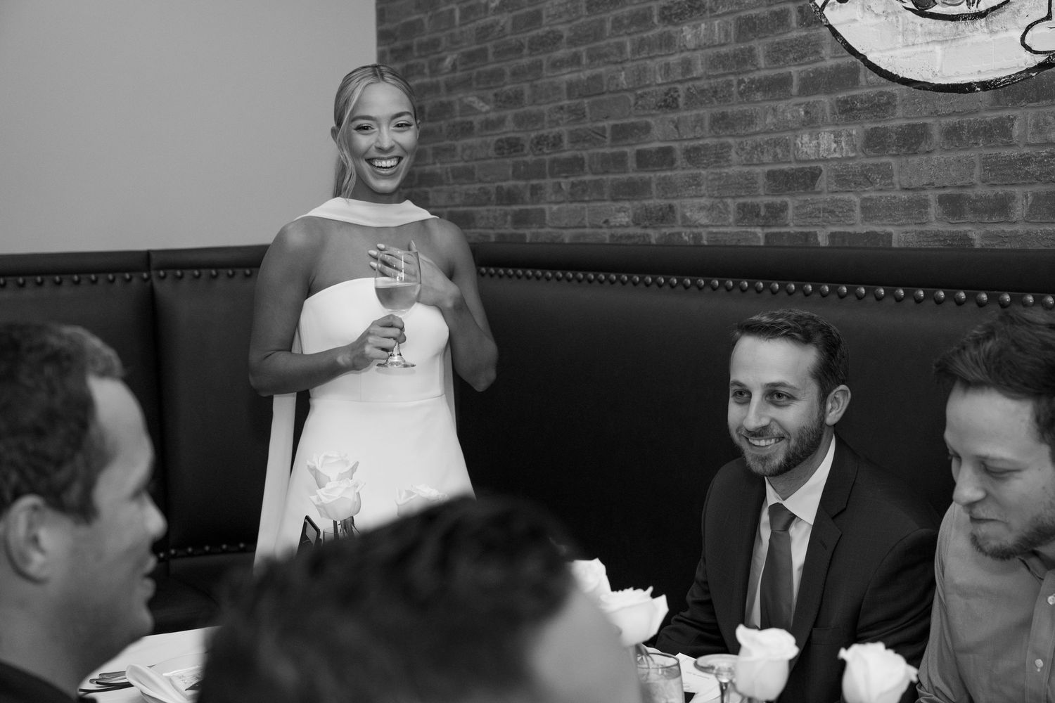 A collage of black and white candid photos showing people laughing and smiling at what appears to be a social gathering.