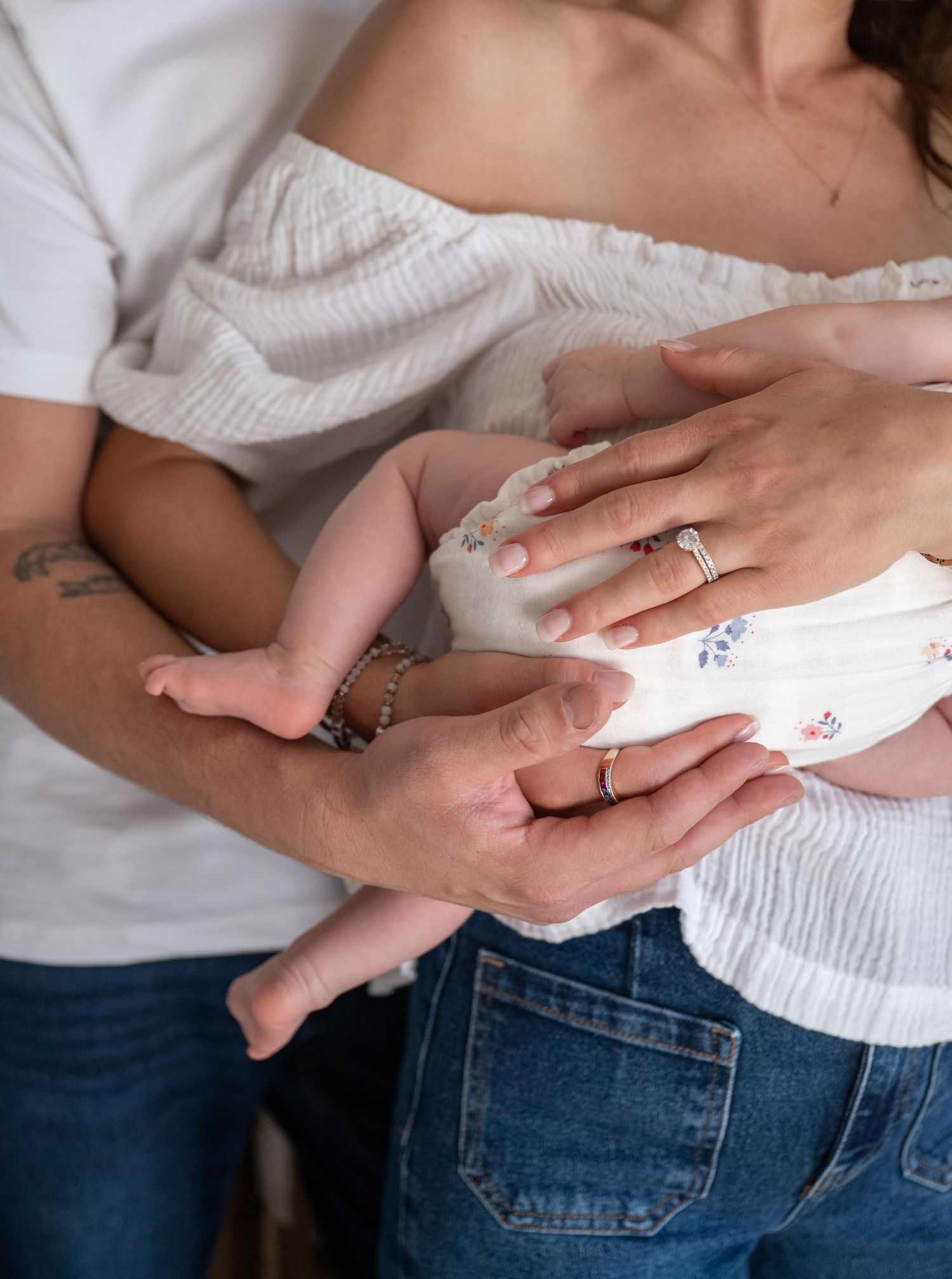 Close-up shot of hands holding and cradling a small baby.