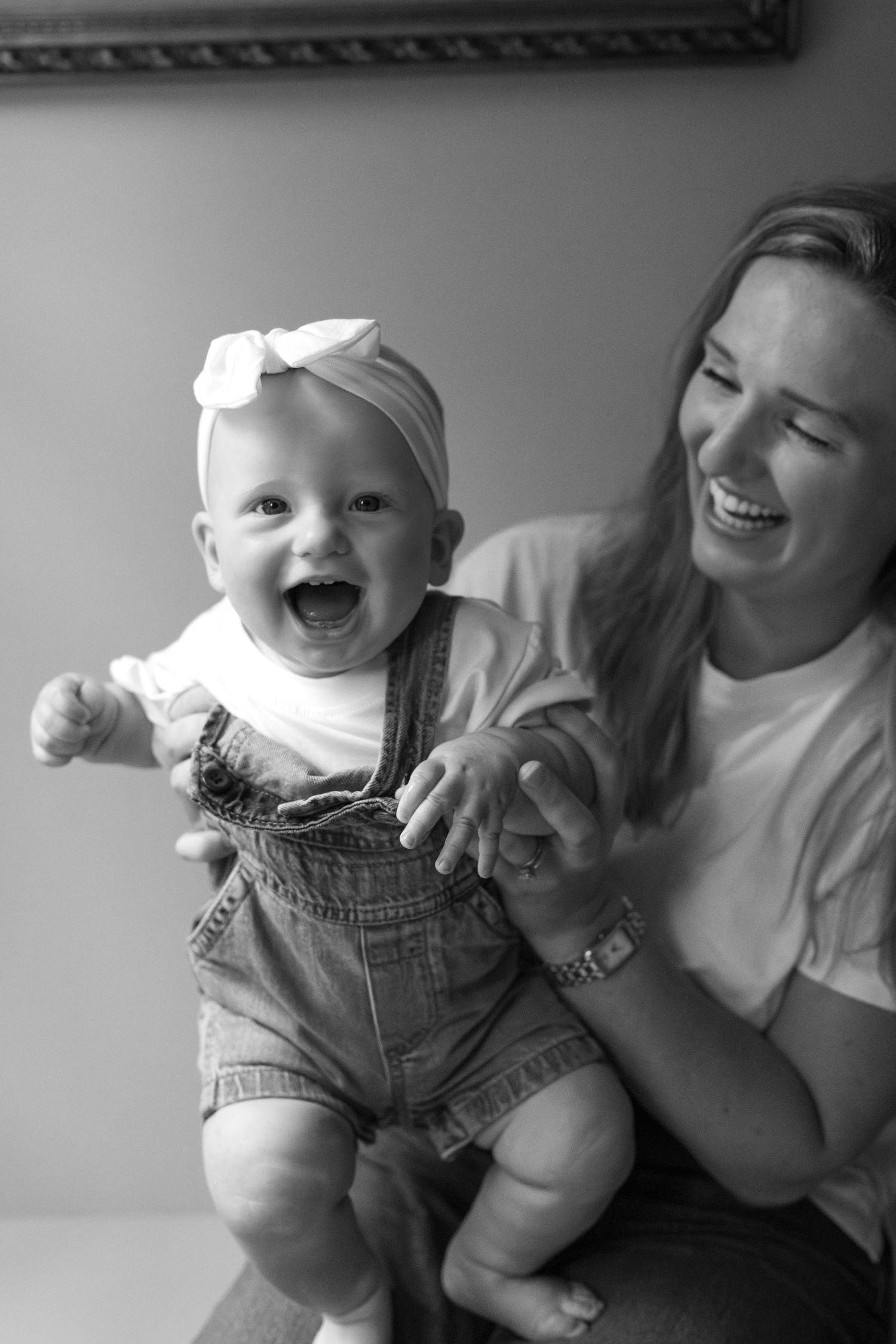 Joyful moments captured in black and white with baby in overalls.