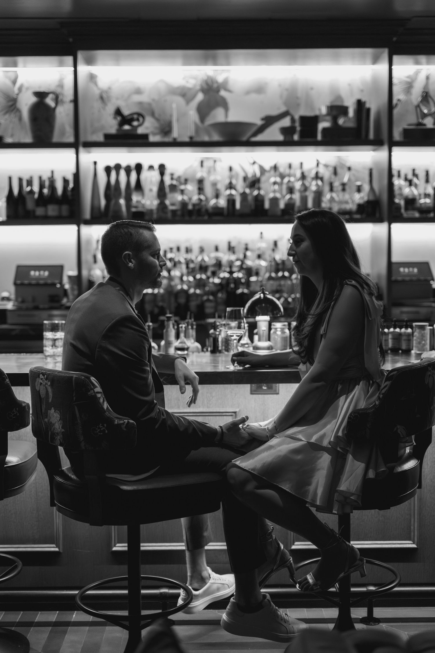 A black and white photo sequence shows two people sitting at a bar counter in silhouette across five frames.