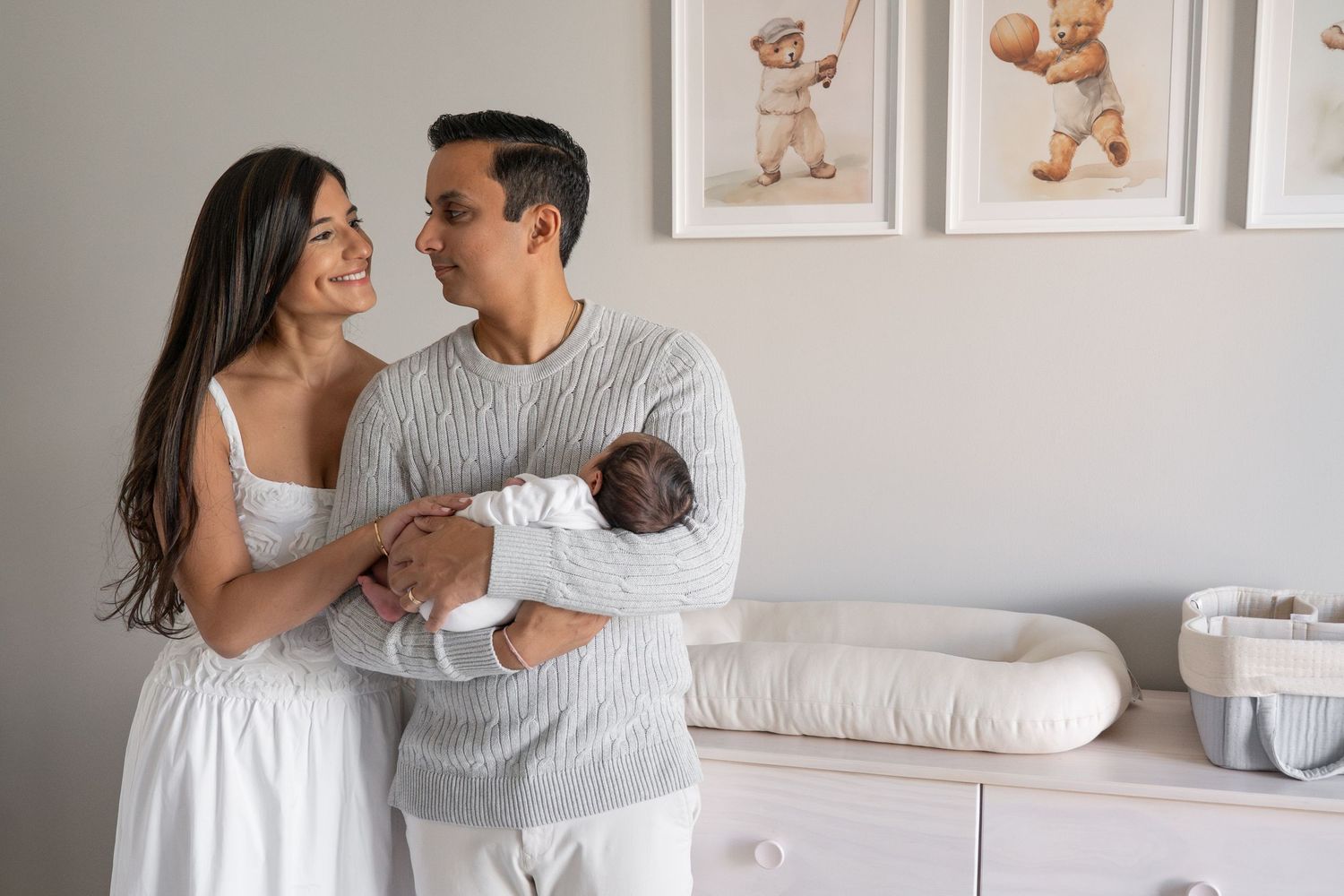 Nursery room scene with teddy bear artwork and white furniture.