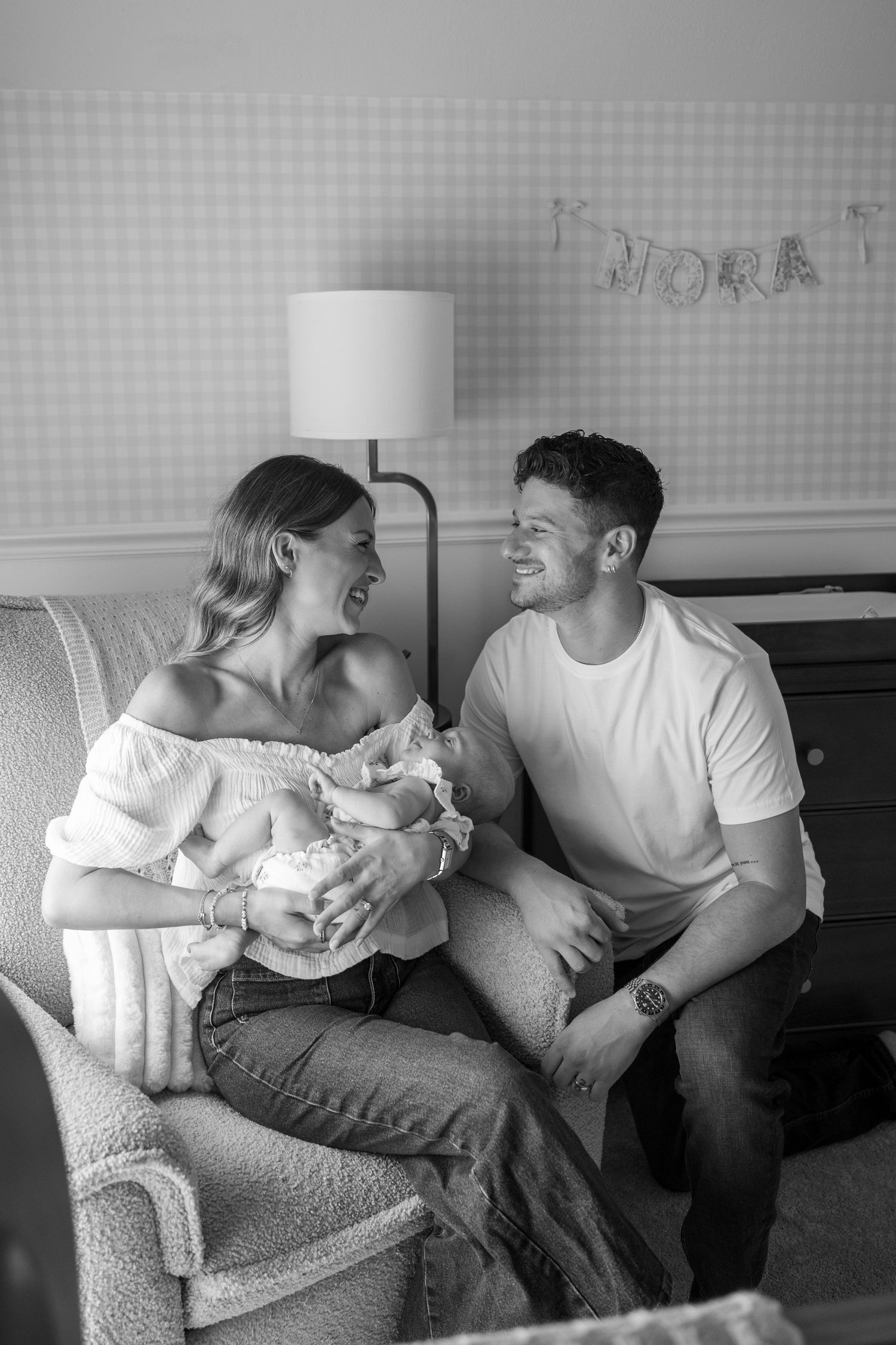 Black and white photo of tender family moment on a couch.