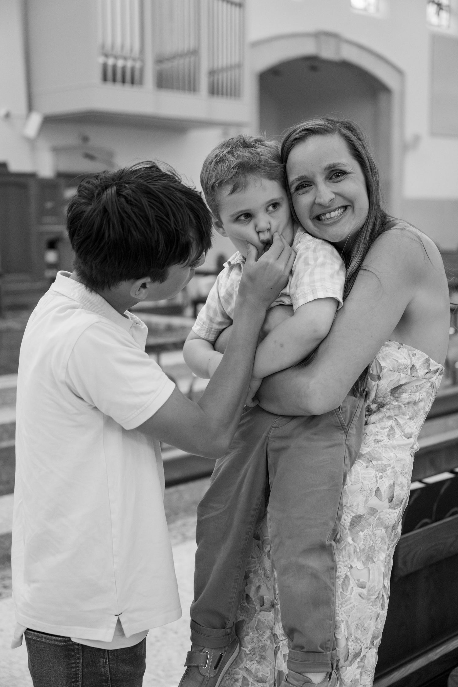 Family sharing a tender moment together in church pews during a special occasion.