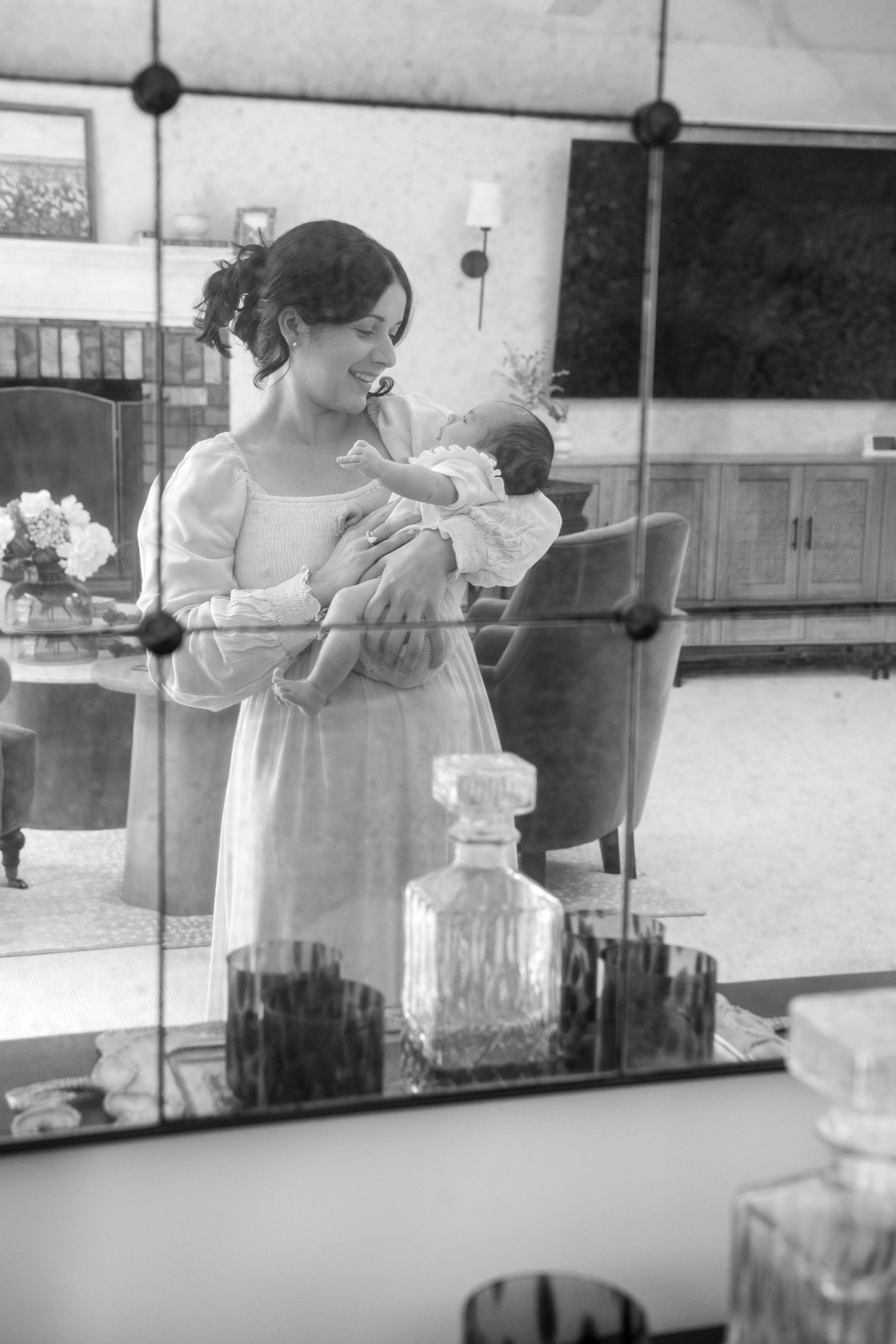 Black and white reflections in mirror showing nurturing moments between parent and child.