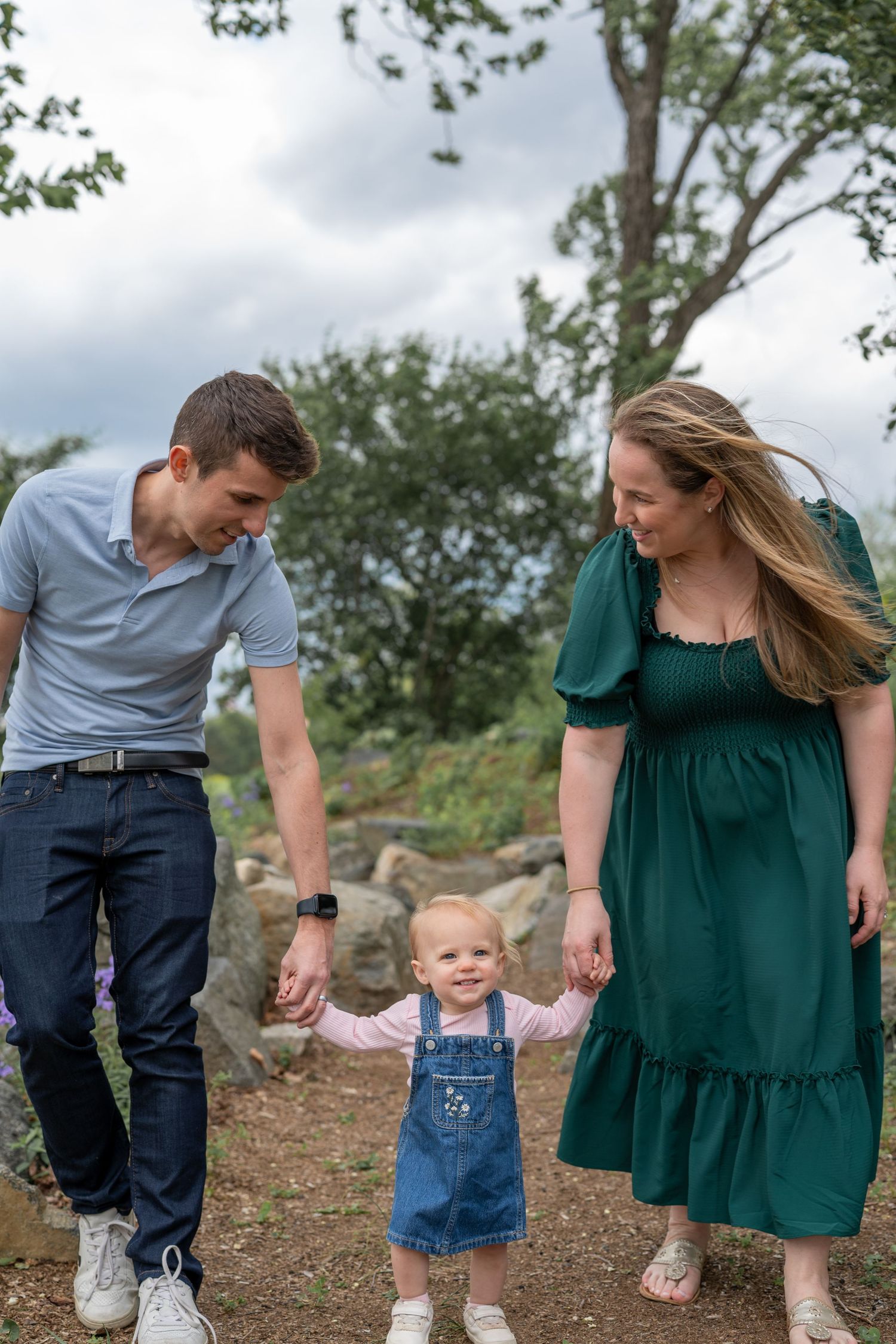 Family walking and playing together on a rocky outdoor path.