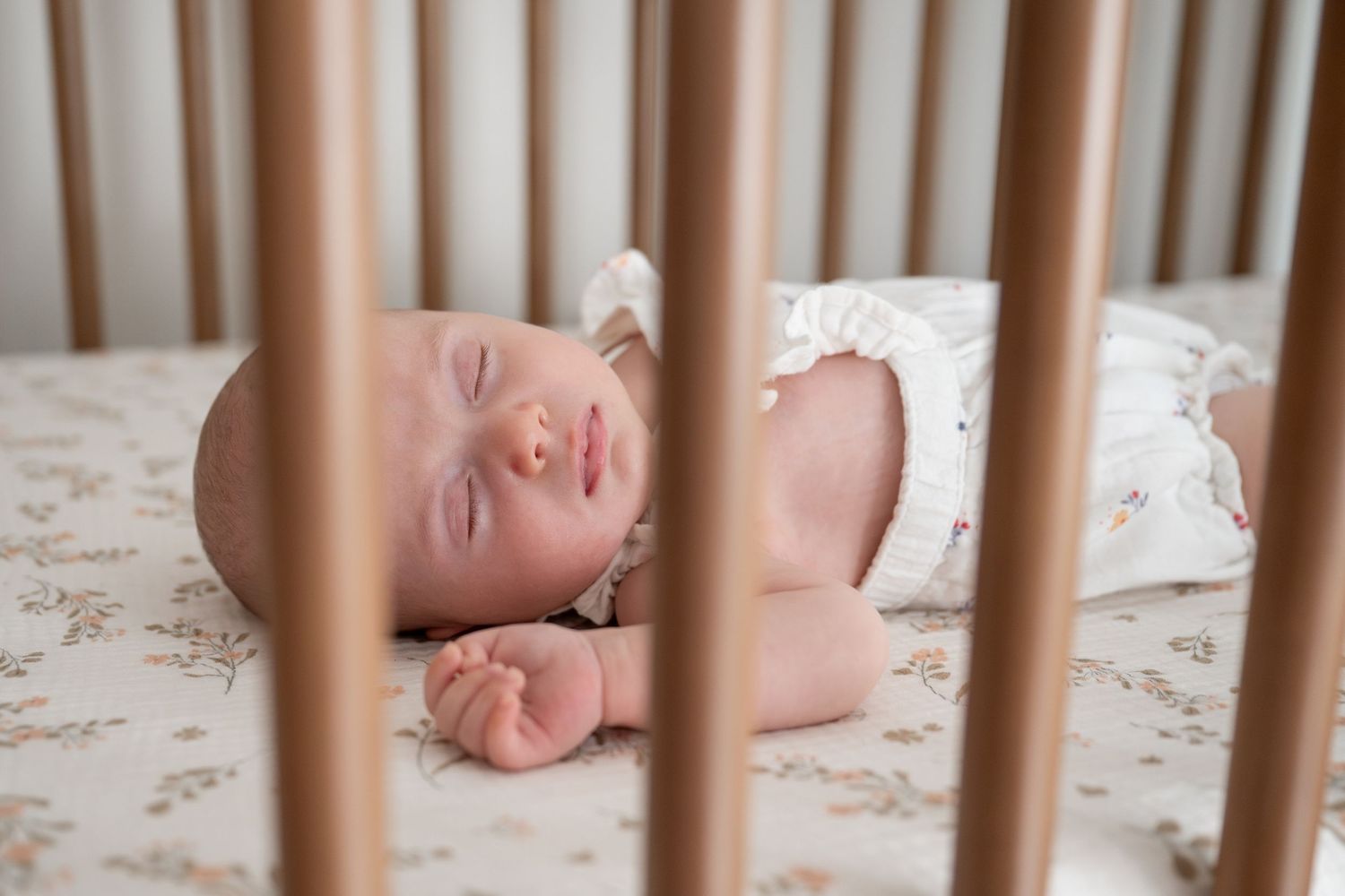 Wooden crib rails with soft bedding visible inside.