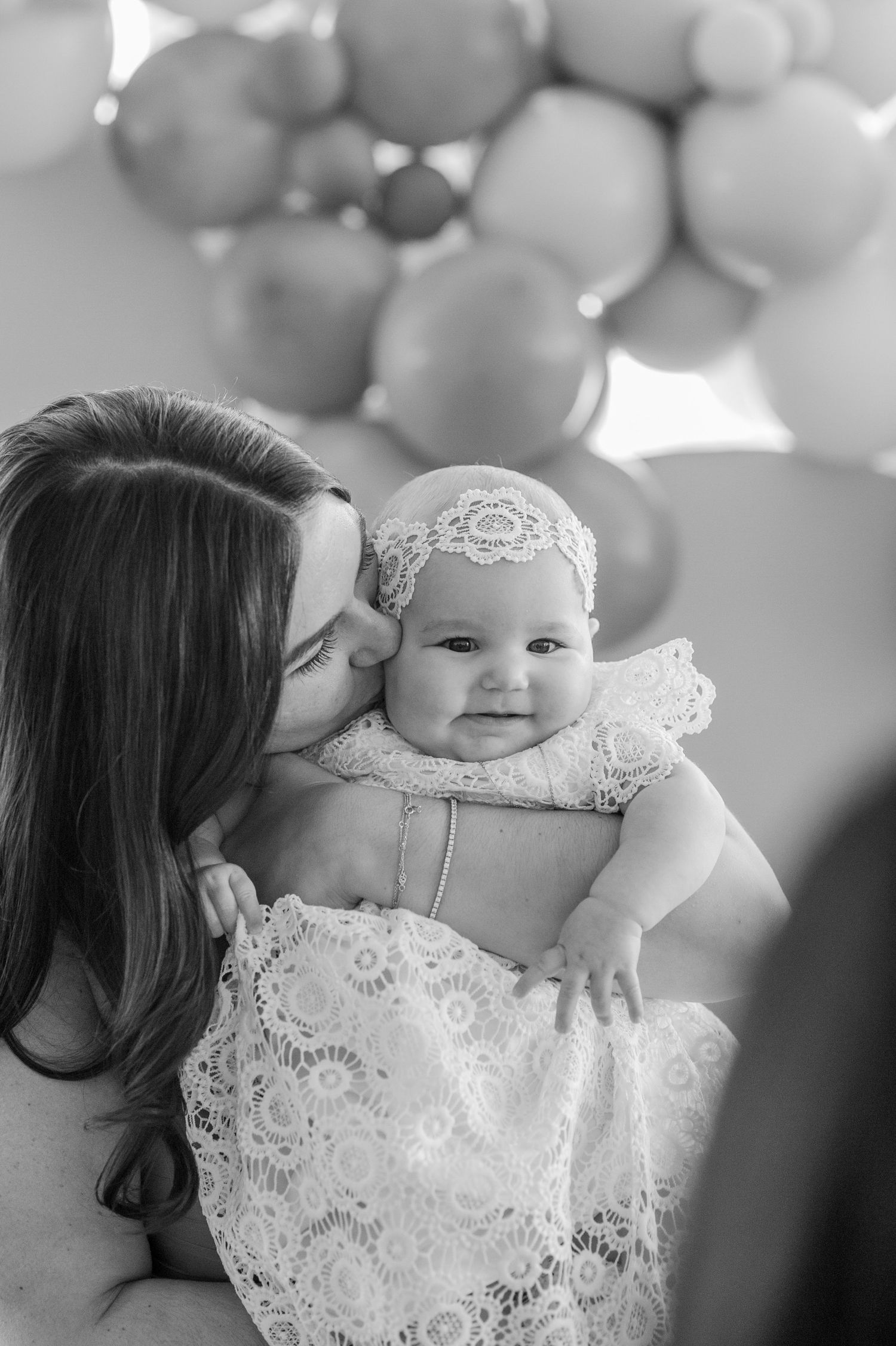 A tender moment captured in black and white with lace details and soft bokeh lighting effects.