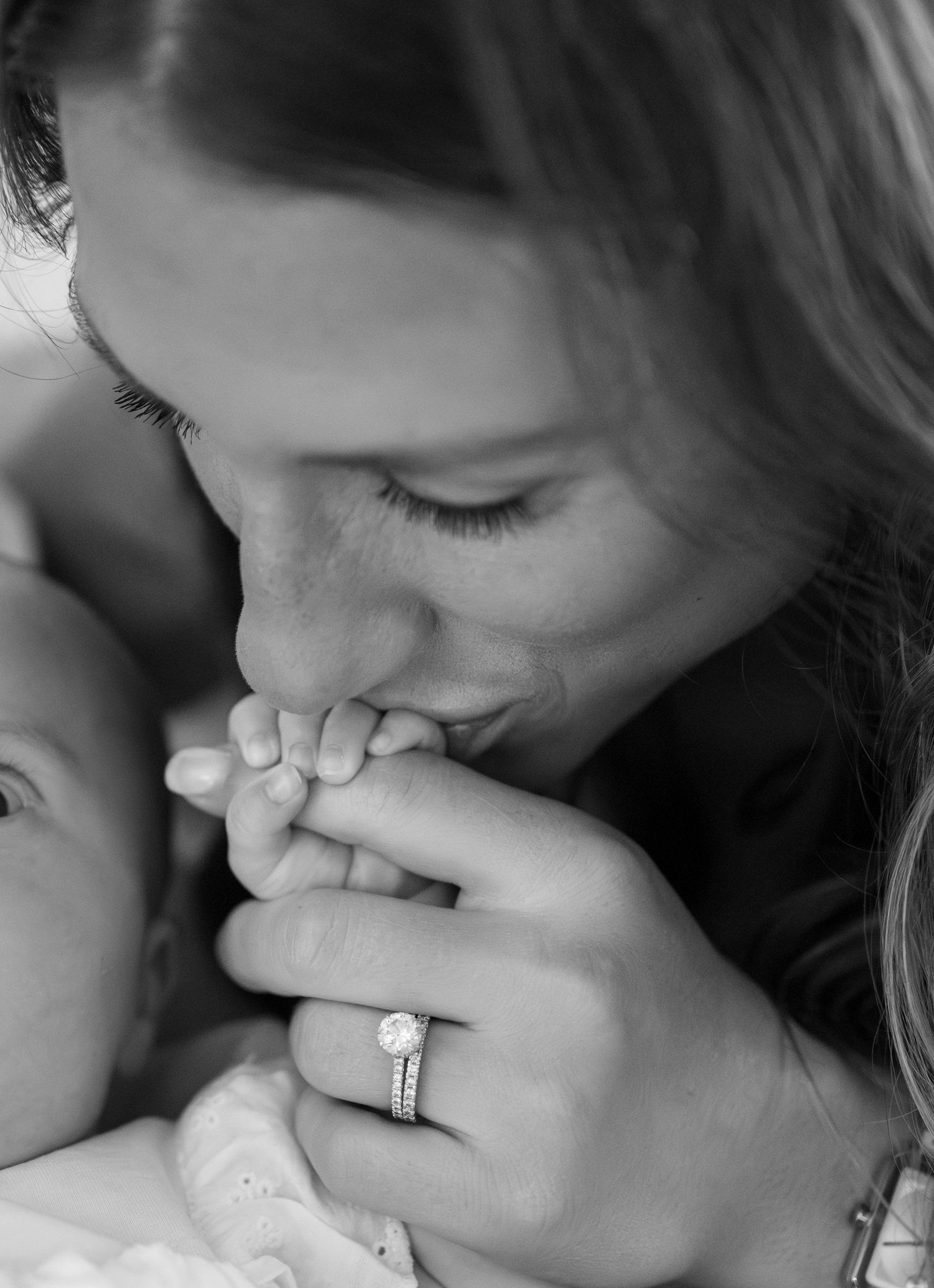 Close-up black and white sequence showing loving kisses on baby's tiny hands.