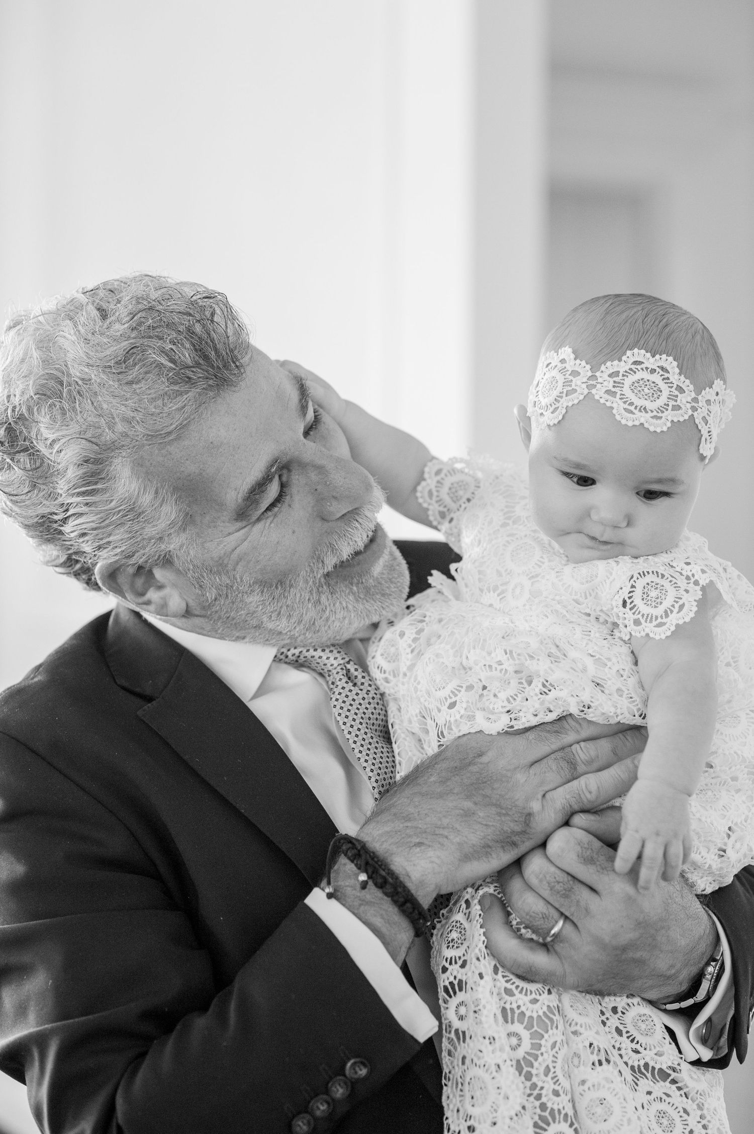 A tender moment during a special ceremony with white lace details.