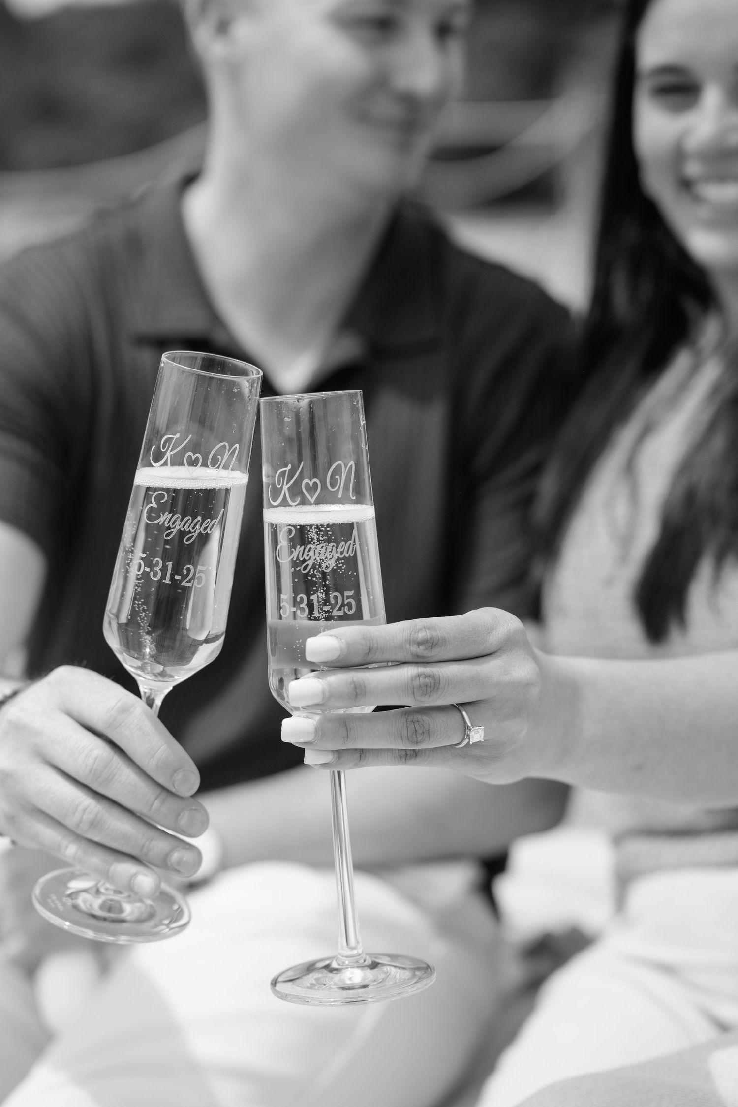 Black and white photo of two champagne glasses being held for a toast.