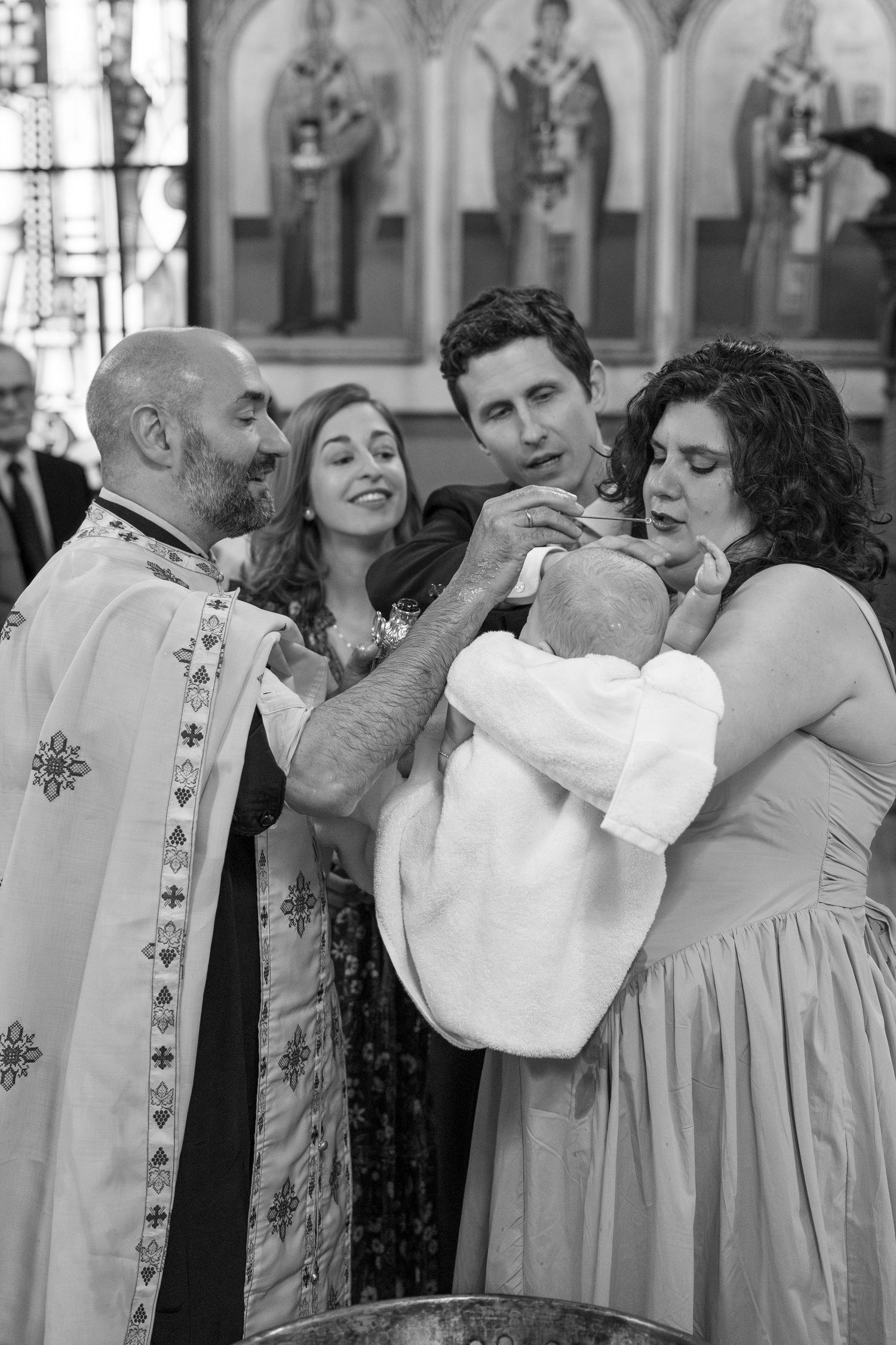 A group gathers in formal attire for a religious ceremony in an ornate church setting.