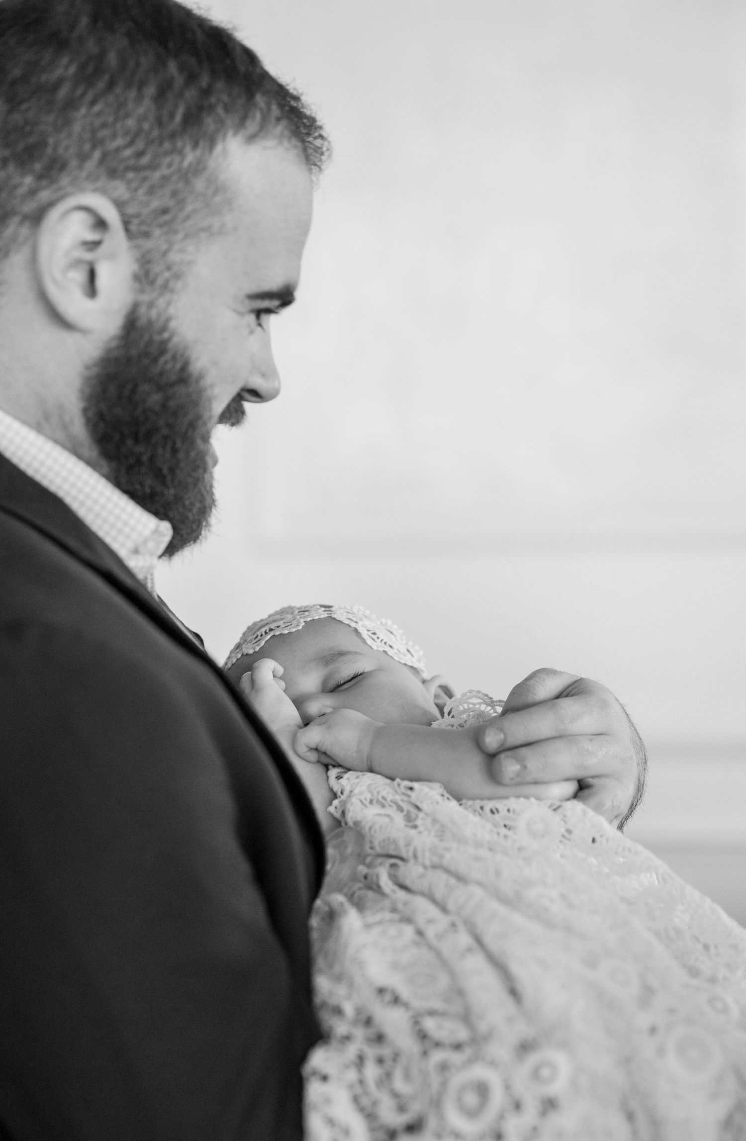 Black and white portrait of a tender moment during a christening ceremony.