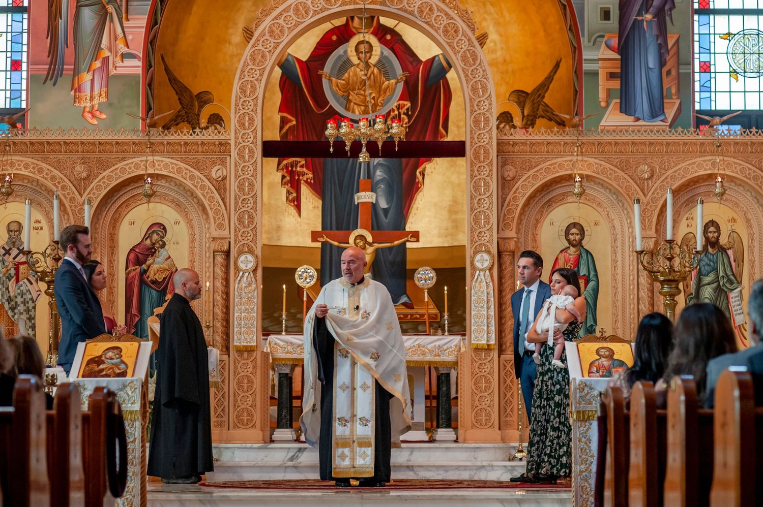 Interior view of an Orthodox church showing ornate religious frescoes, icons and decorative artwork on the walls and ceiling.