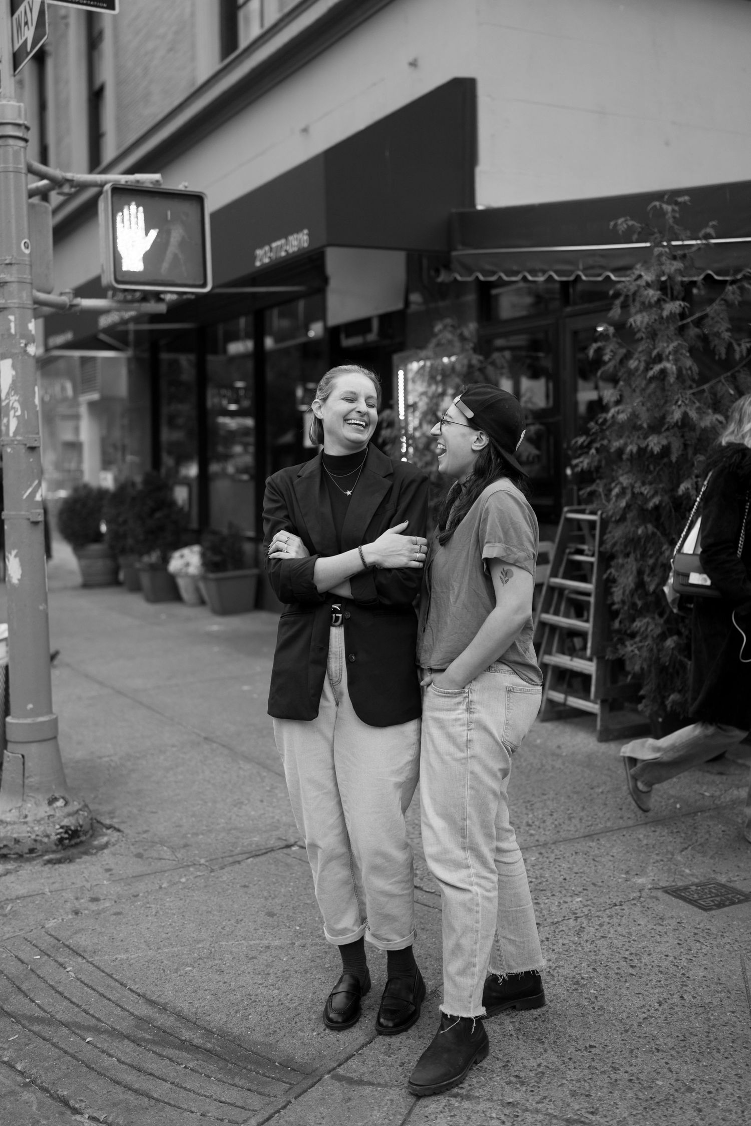 People conversing outside storefronts in black and white photography.