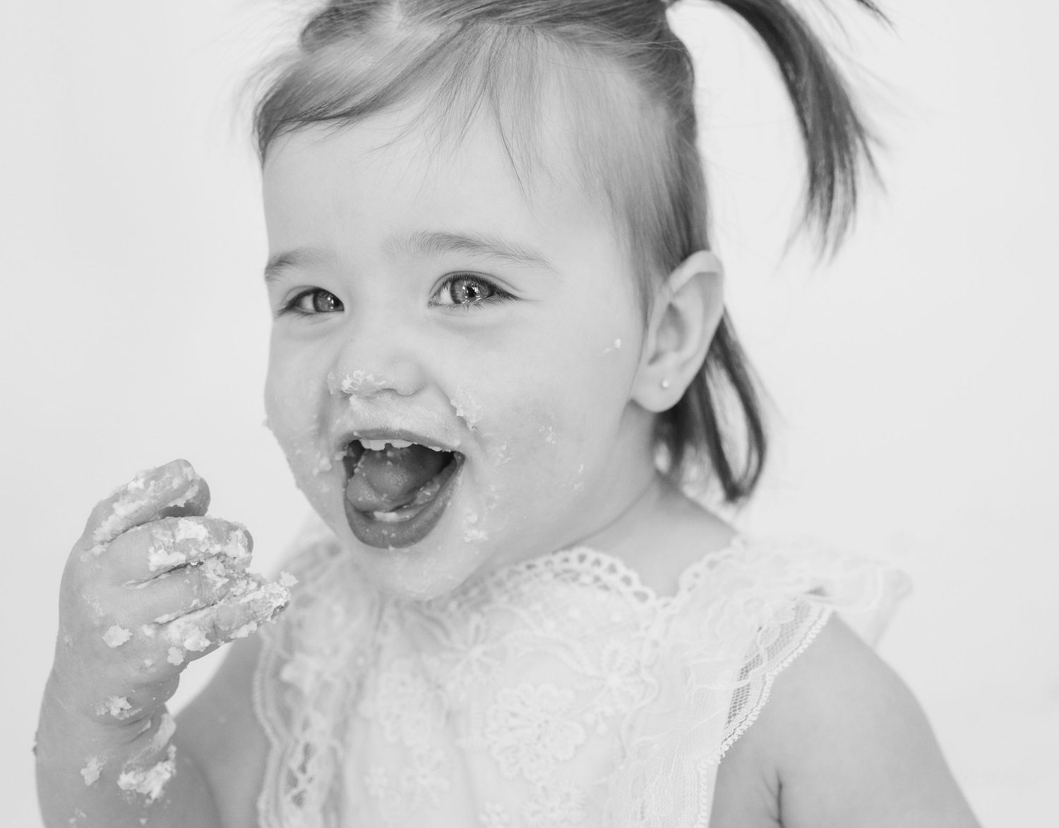 Black and white sequence showing baby's joyful reactions during cake smash photography.