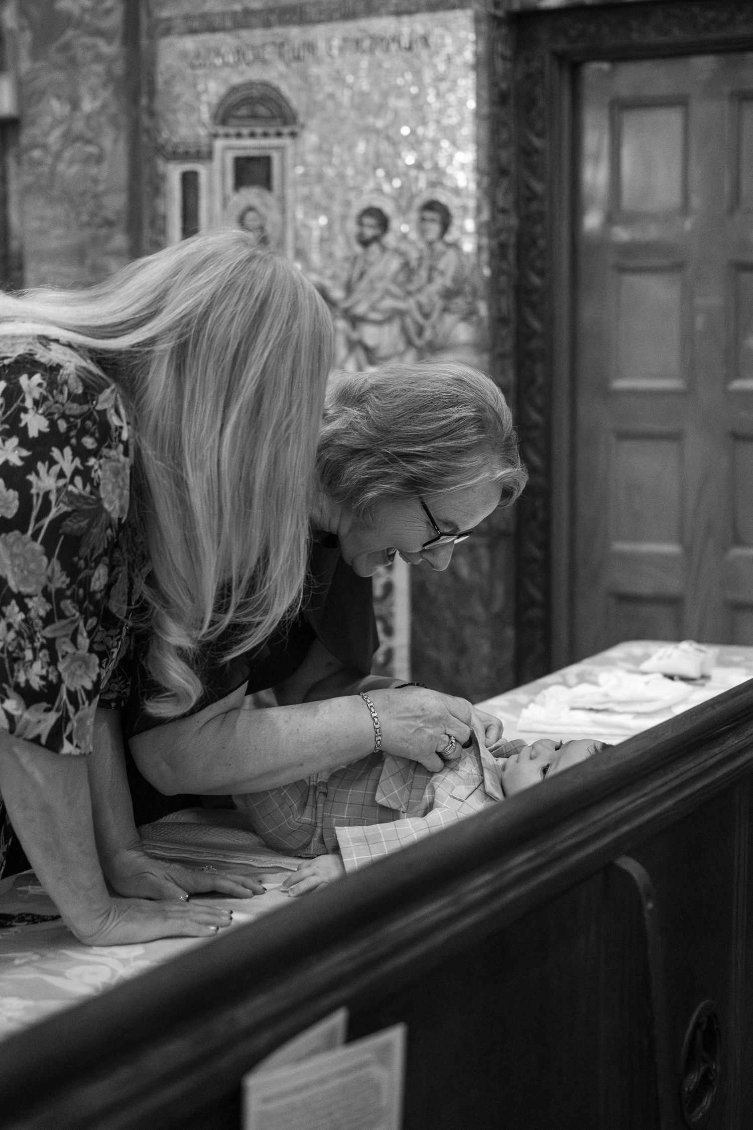 A black and white photo showing people signing documents in a church or religious setting.