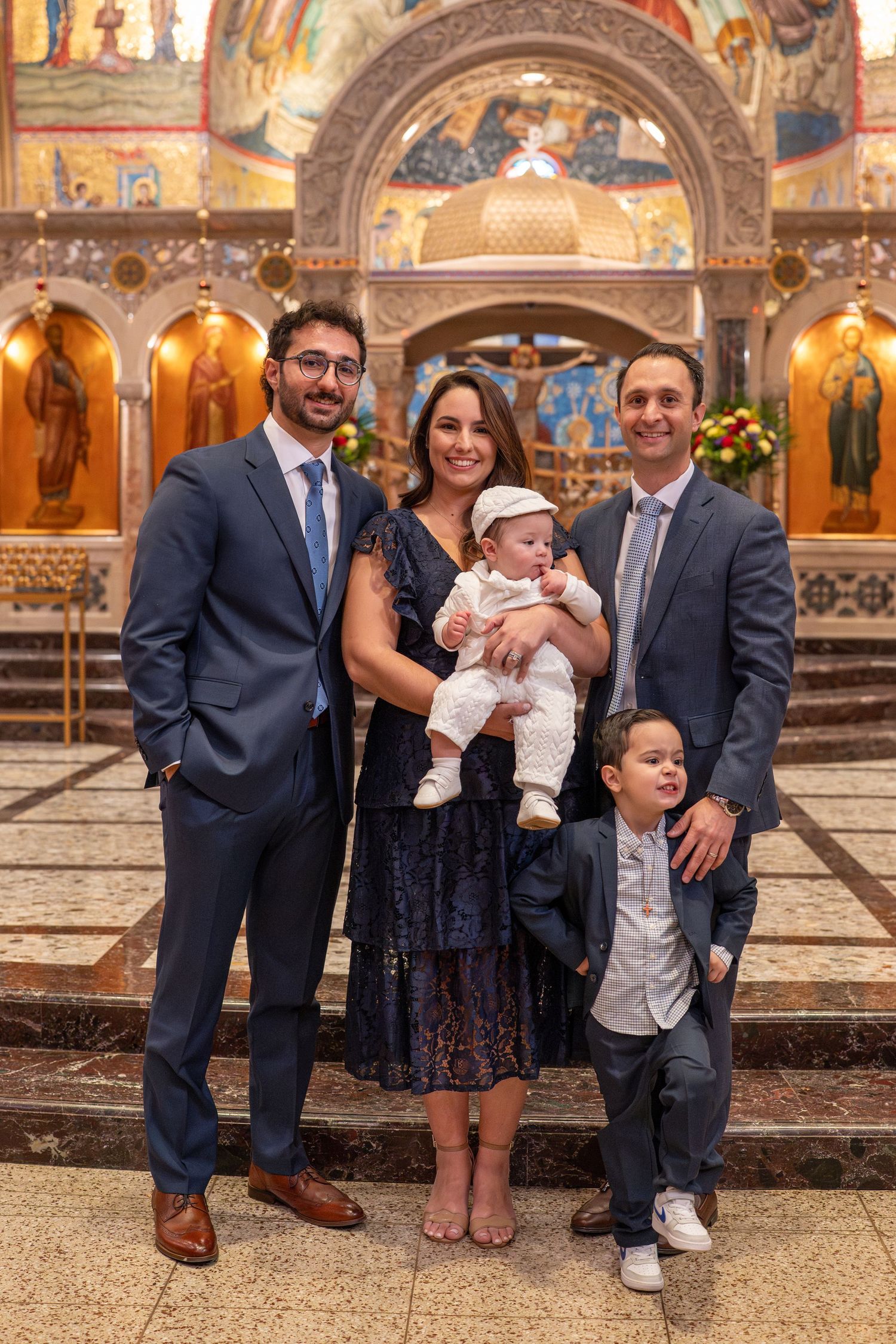 Family group photos in formal attire gathered inside an ornate church with decorated arches and religious artwork.