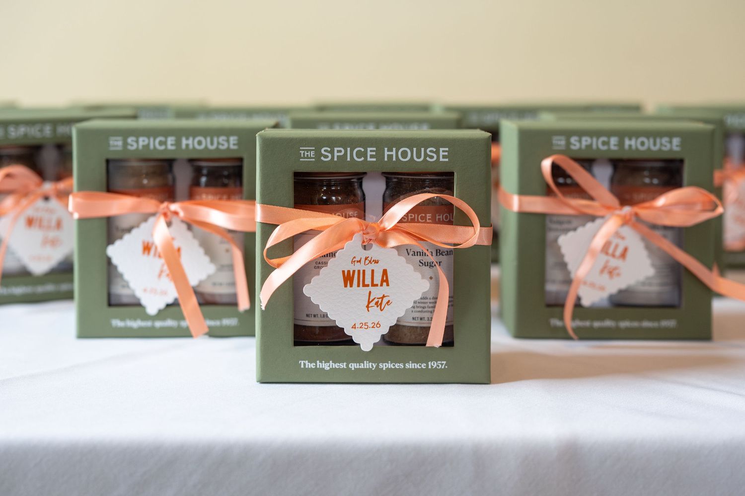 Spice House gift boxes tied with orange ribbon personalized for baby Willa displayed on a table.