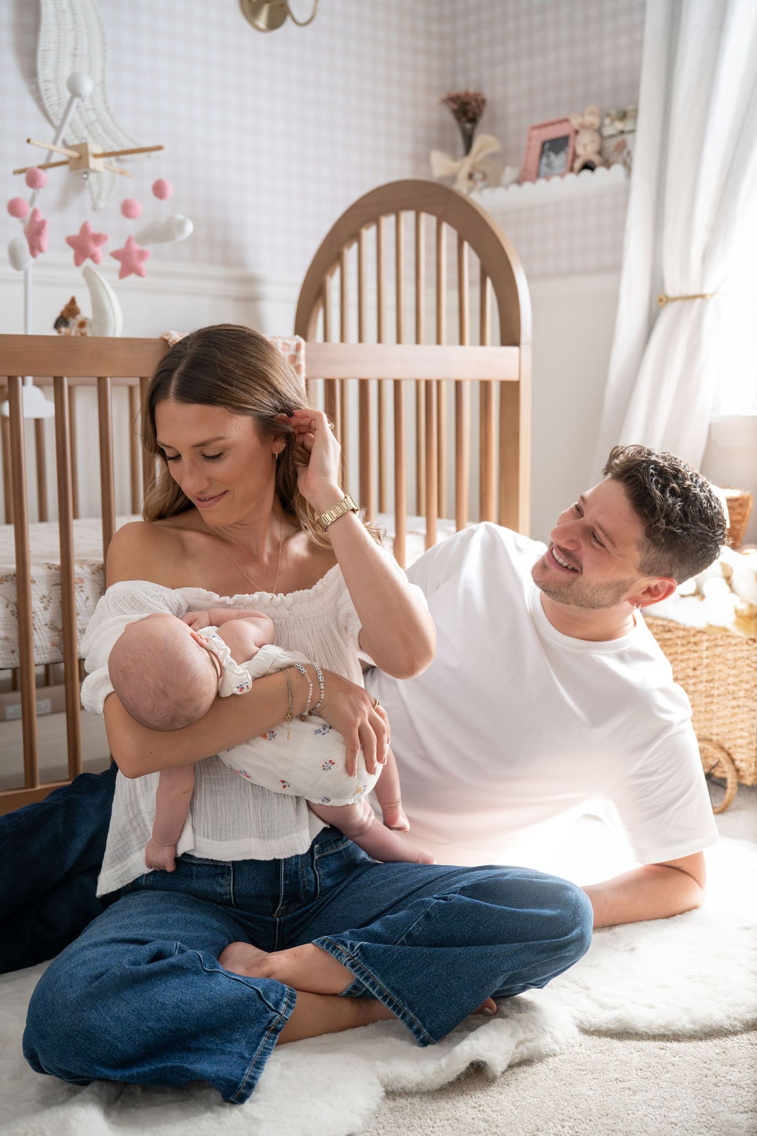 Sweet family moments captured in color showing parents bonding with baby on white carpet.