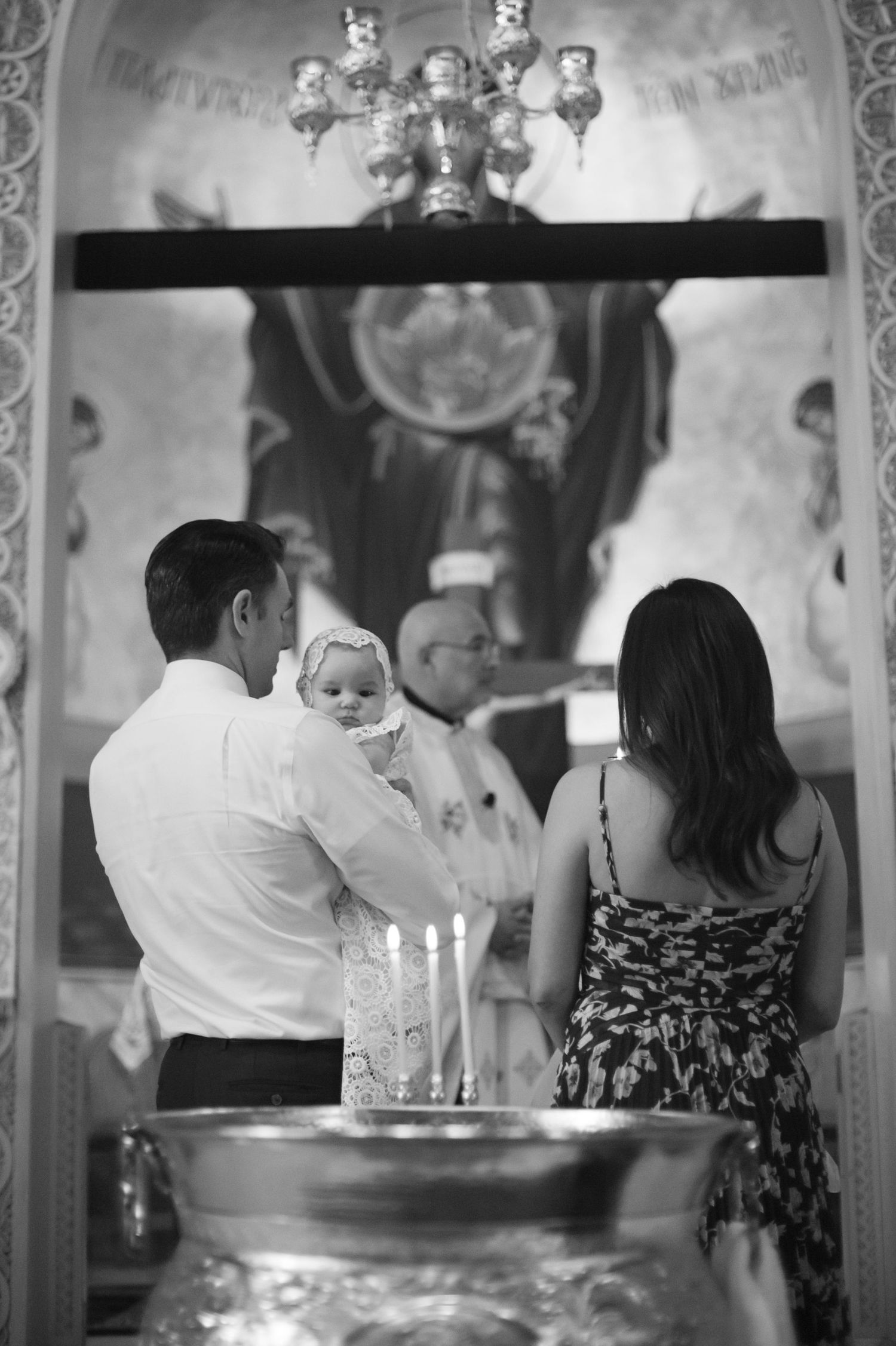 A church ceremony with candles and decorative murals in the background.