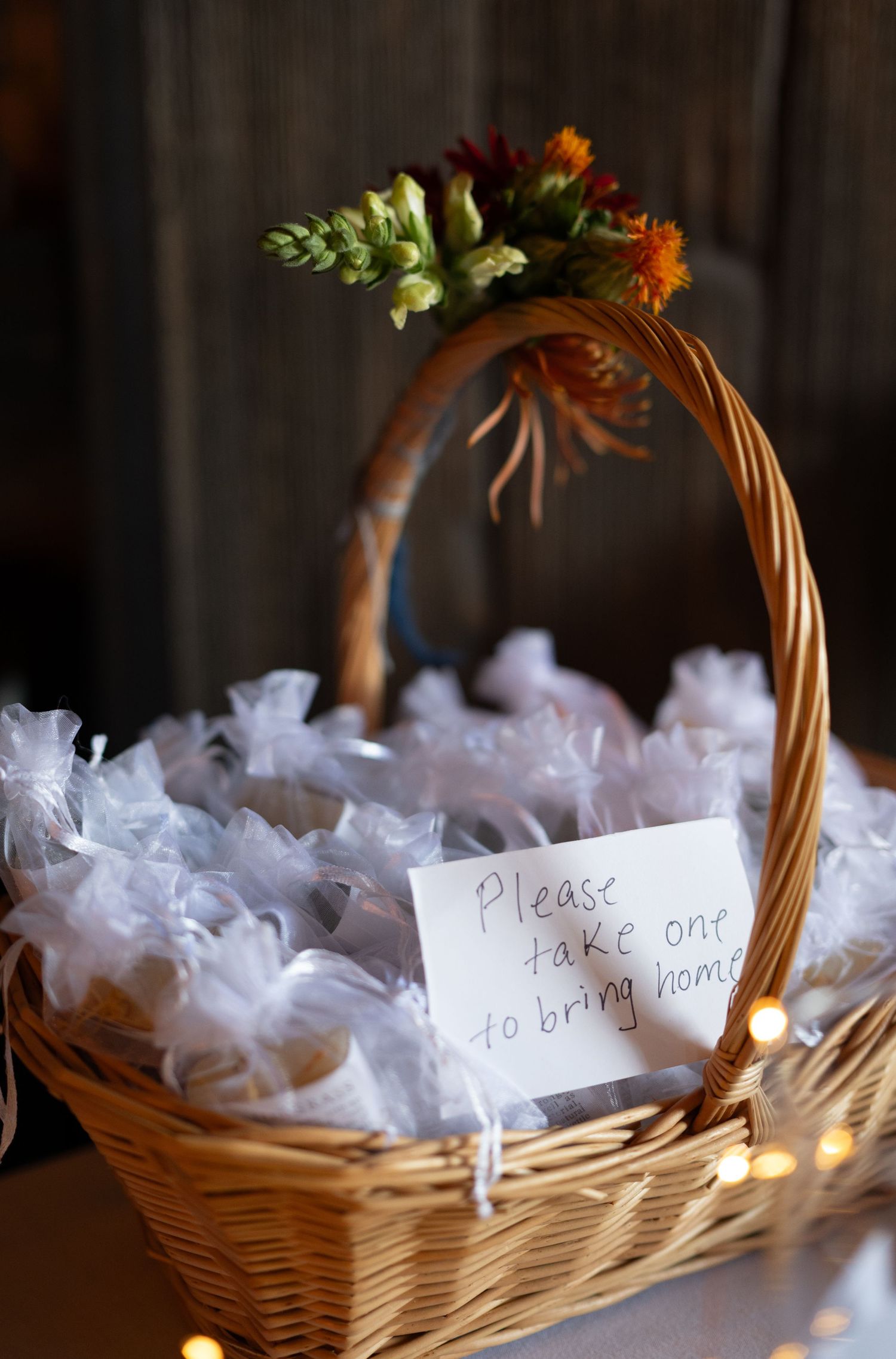 Wicker baskets filled with white tulle favors and handwritten notes for a baby shower celebration.