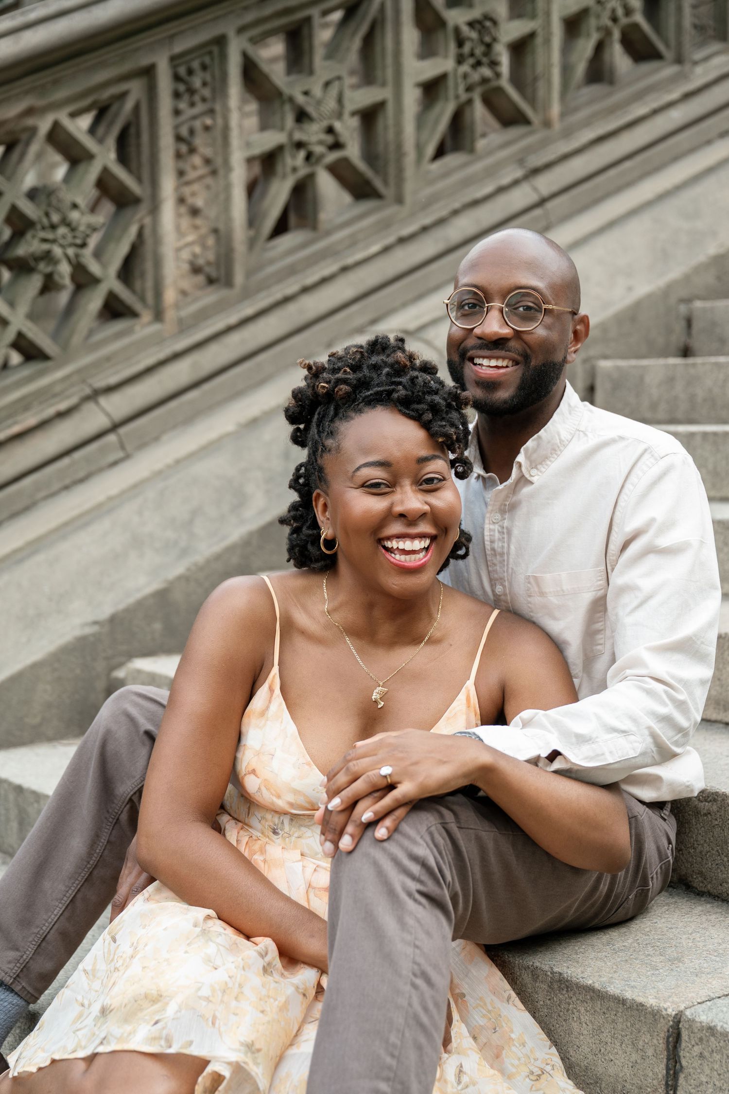 A romantic couple sitting on stone steps sharing intimate moments and laughter.