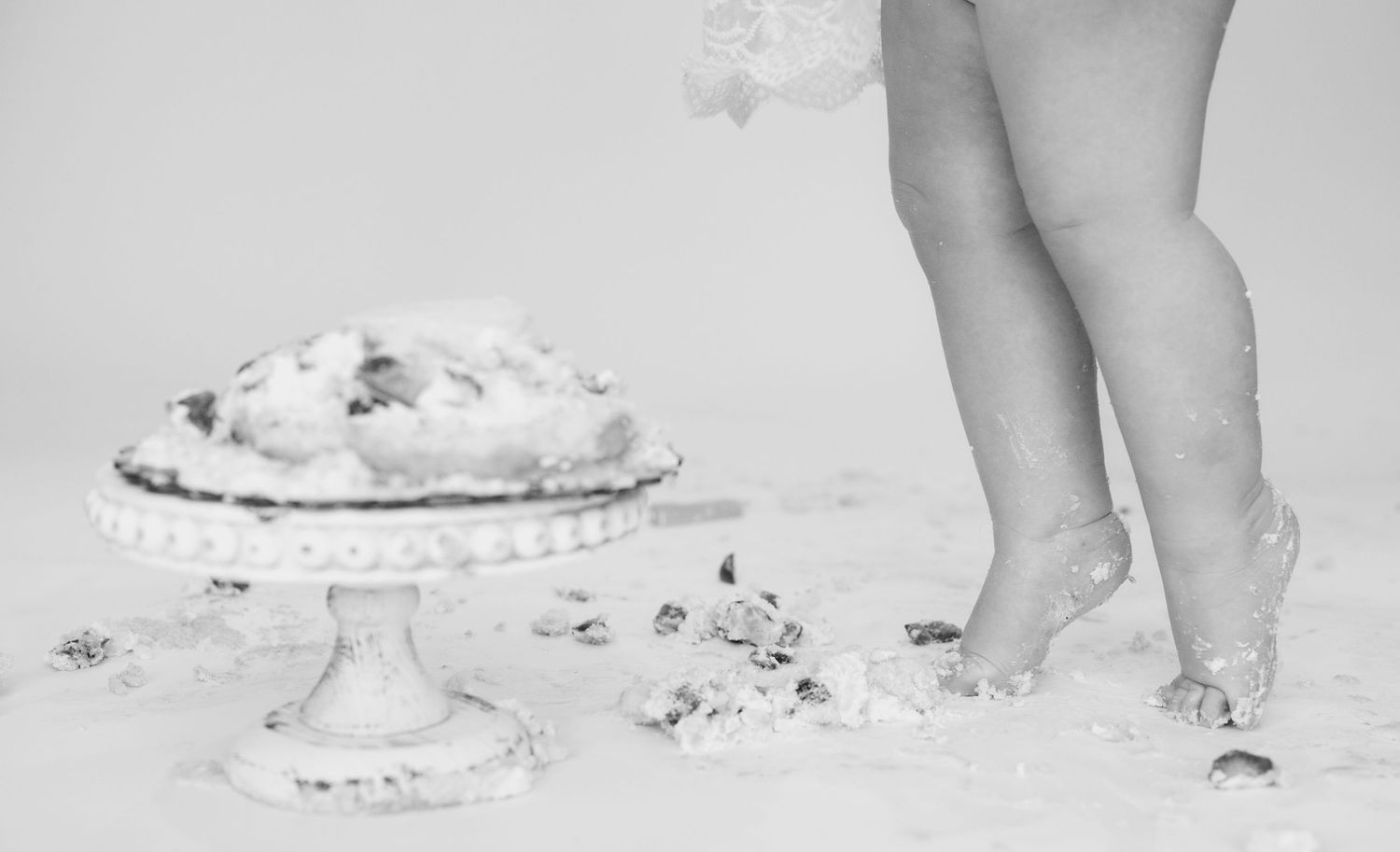 A series of black and white photos showing feet stepping in cake or frosting.