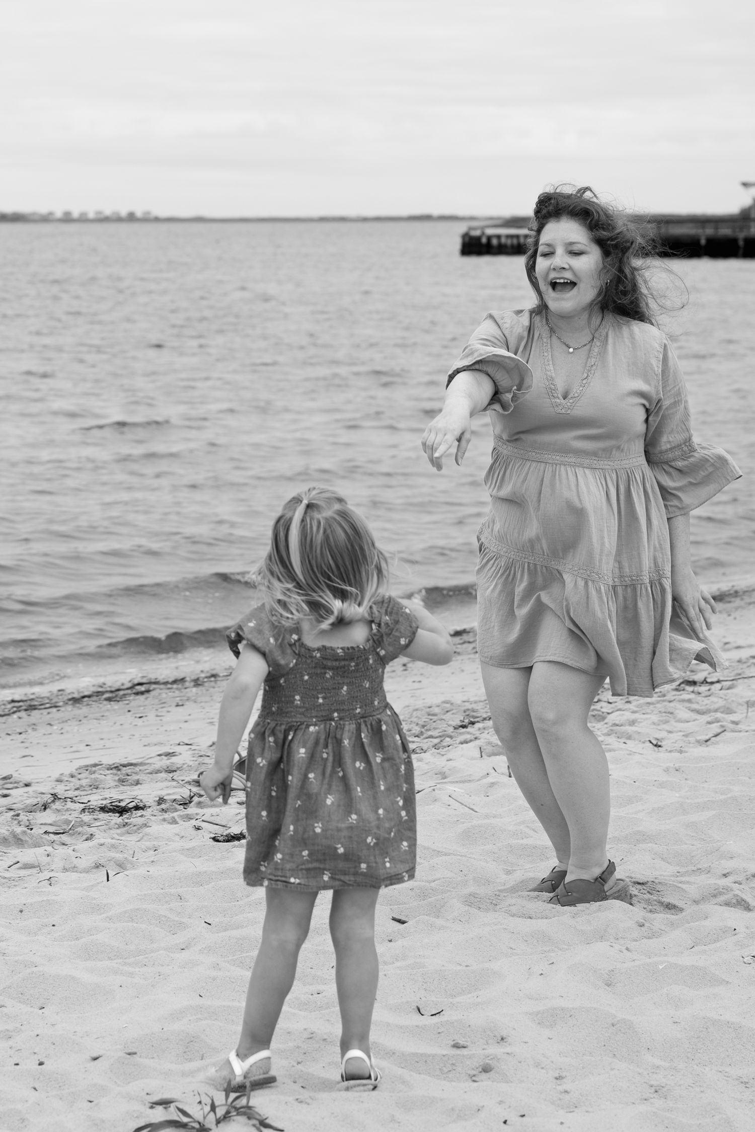 Candid black and white beach photos showing joyful movement and connection.