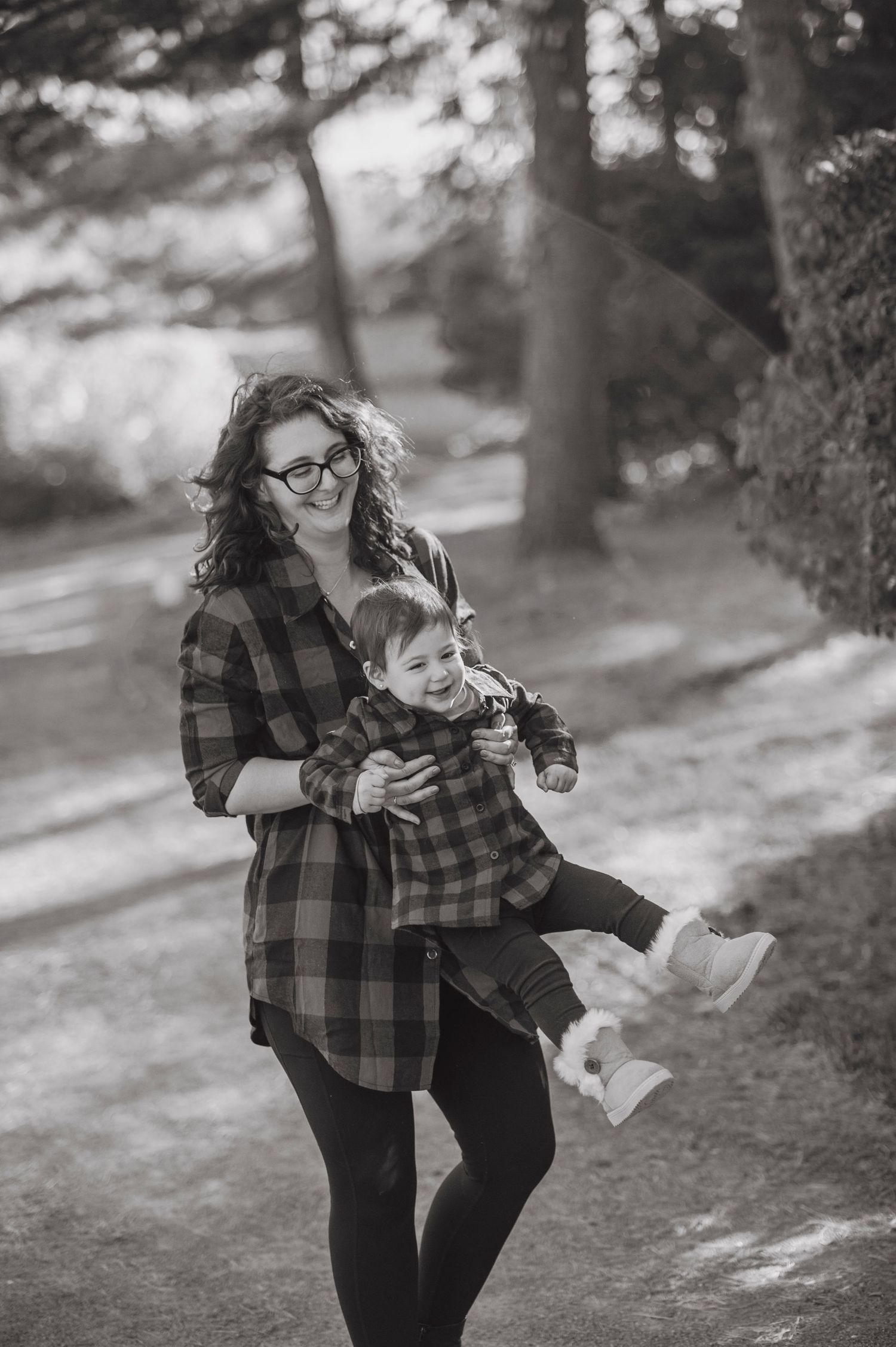 Black and white sequence of someone in plaid shirt playing with leaves in a park setting.