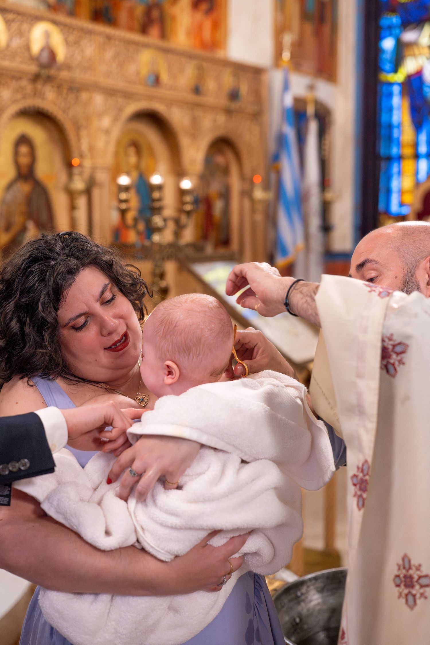 A joyful moment during a baptism ceremony as family members celebrate with the baby.